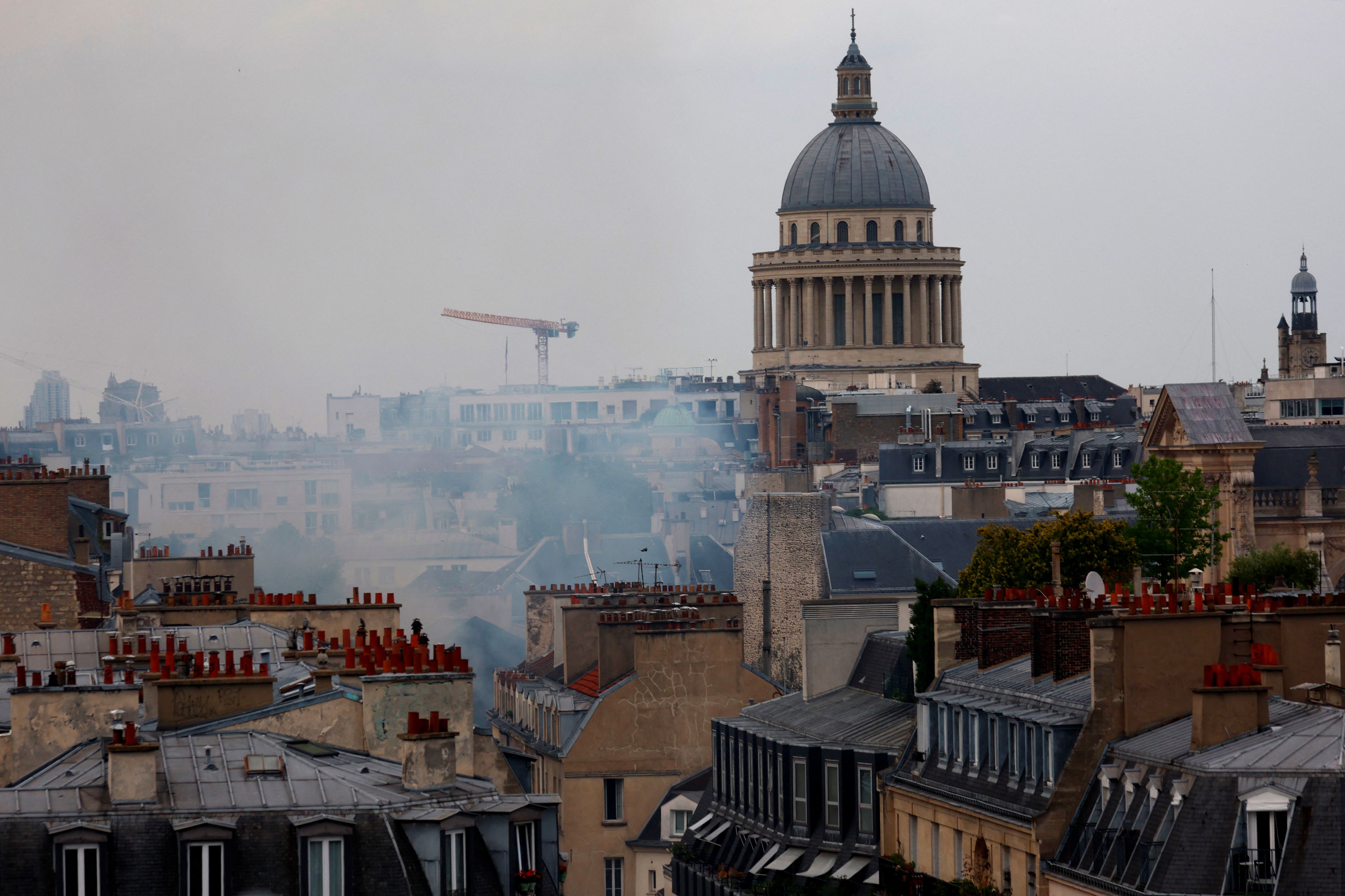 Smoke rising above the rooftops of Paris with the Pantheon in the background