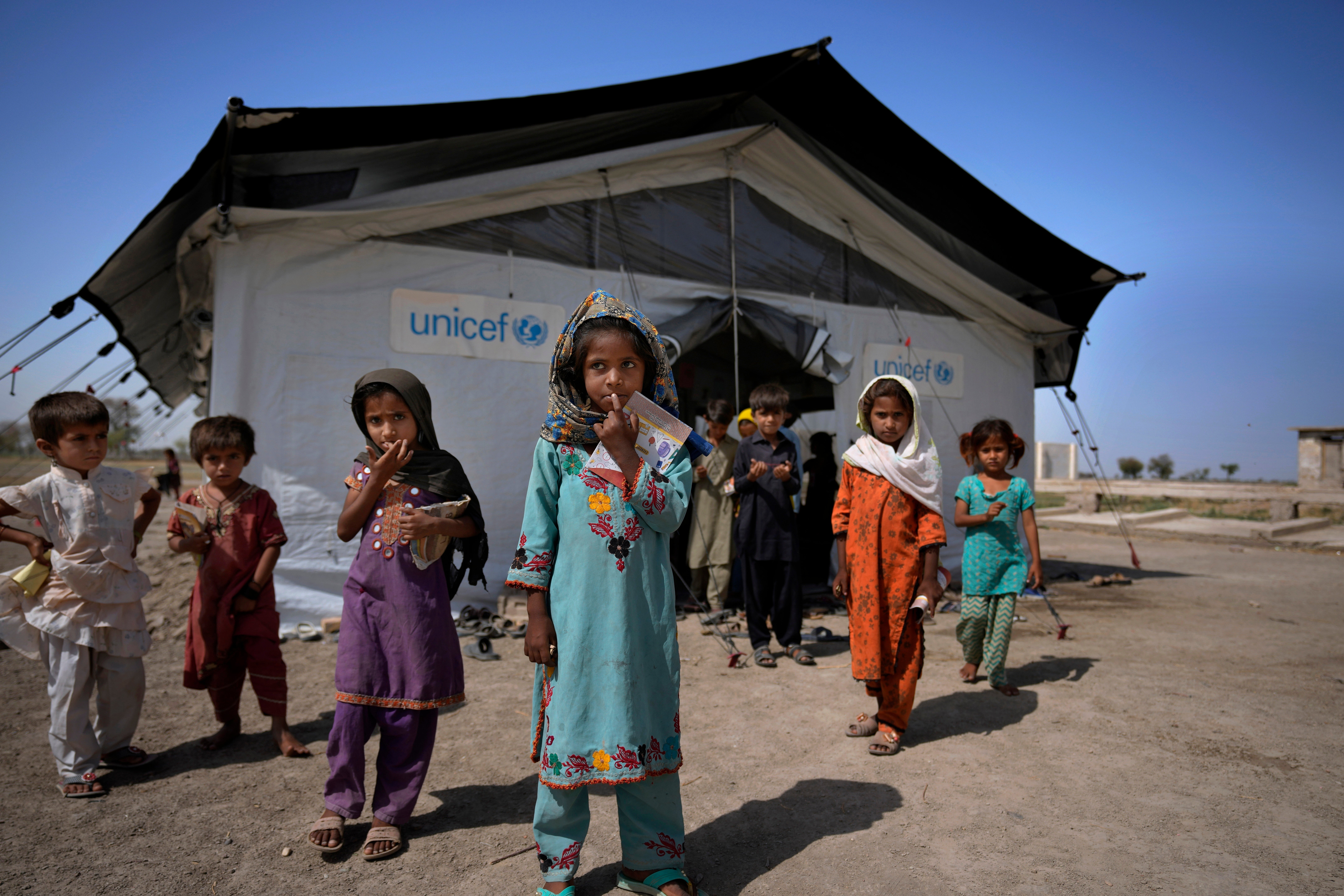 <p>Flood victims leave a school set up in a tent, caused by last year's floods, in Arzi Naich village in Dada, a district of Pakistan's Sindh province</p>