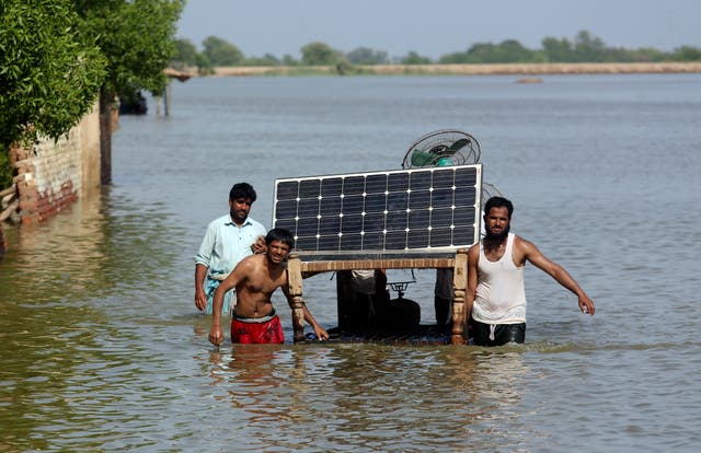 <p>File. Men use a cot to salvage belongings, including a solar panel, from their flooded home in Jaffarabad, Pakistan, on 5 September 2022</p>