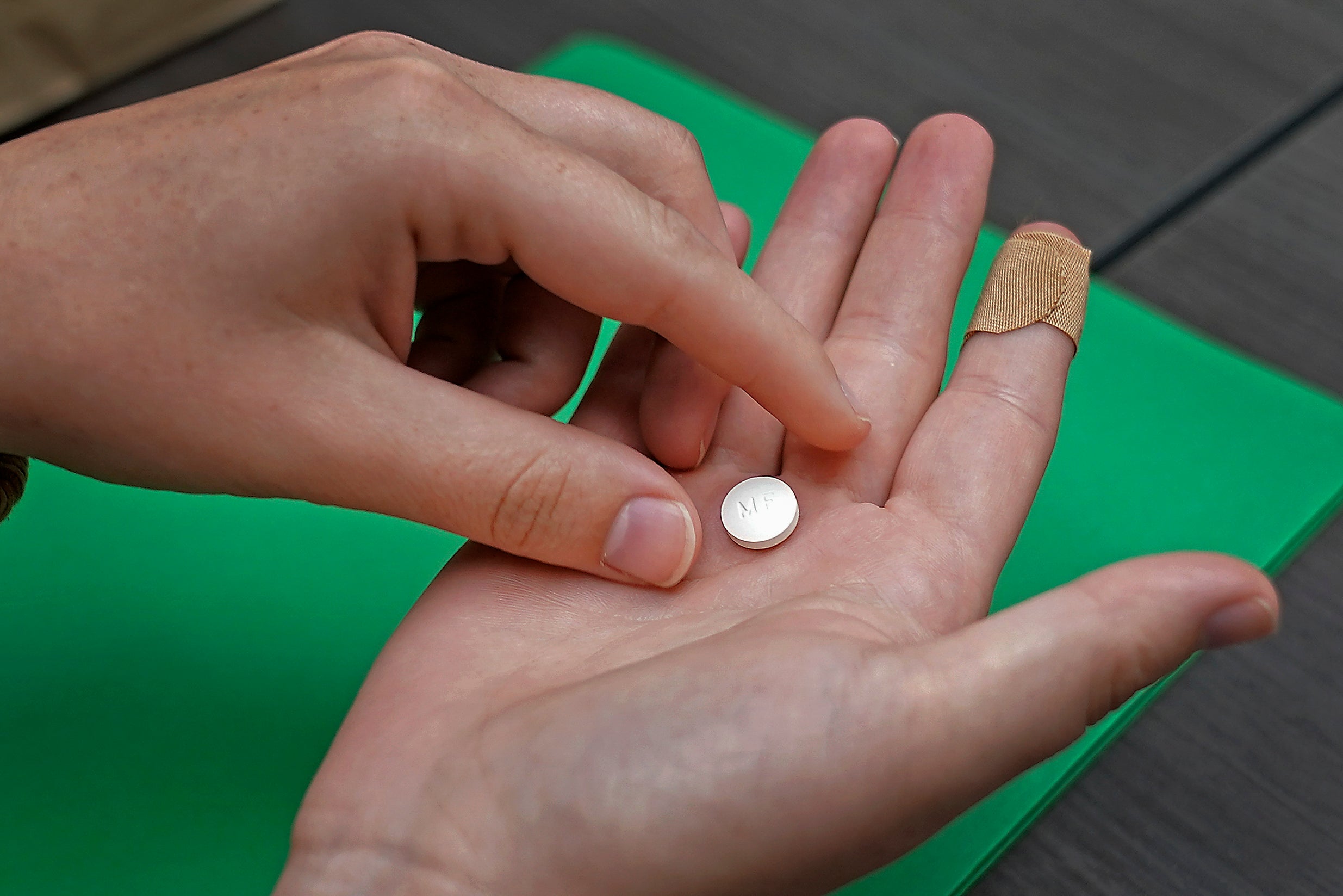 A patient prepares to take the first of two combination pills, mifepristone