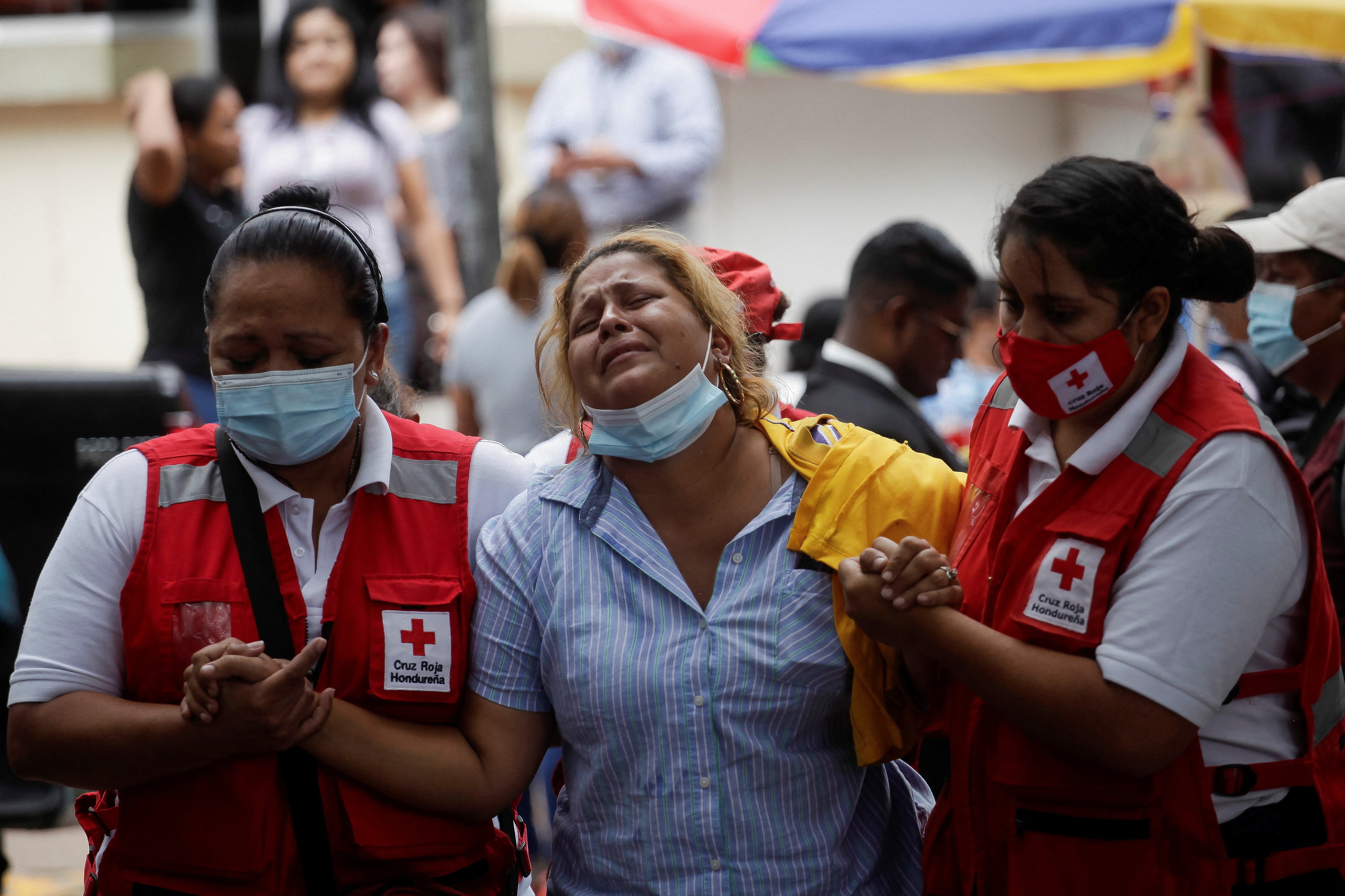 The relative of a victim of the deadly prison riot at the Centro Femenino de Adaptacion Social (CEFAS) women’s prison is helped by Red Cross paramedics outside a morgue in Tegucigalpa, Honduras