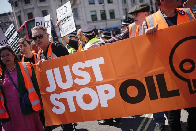 Water appeared to be thrown from a balcony onto Just Stop Oil (JSO) protesters slow marching on a London road (Aaron Chown/PA)