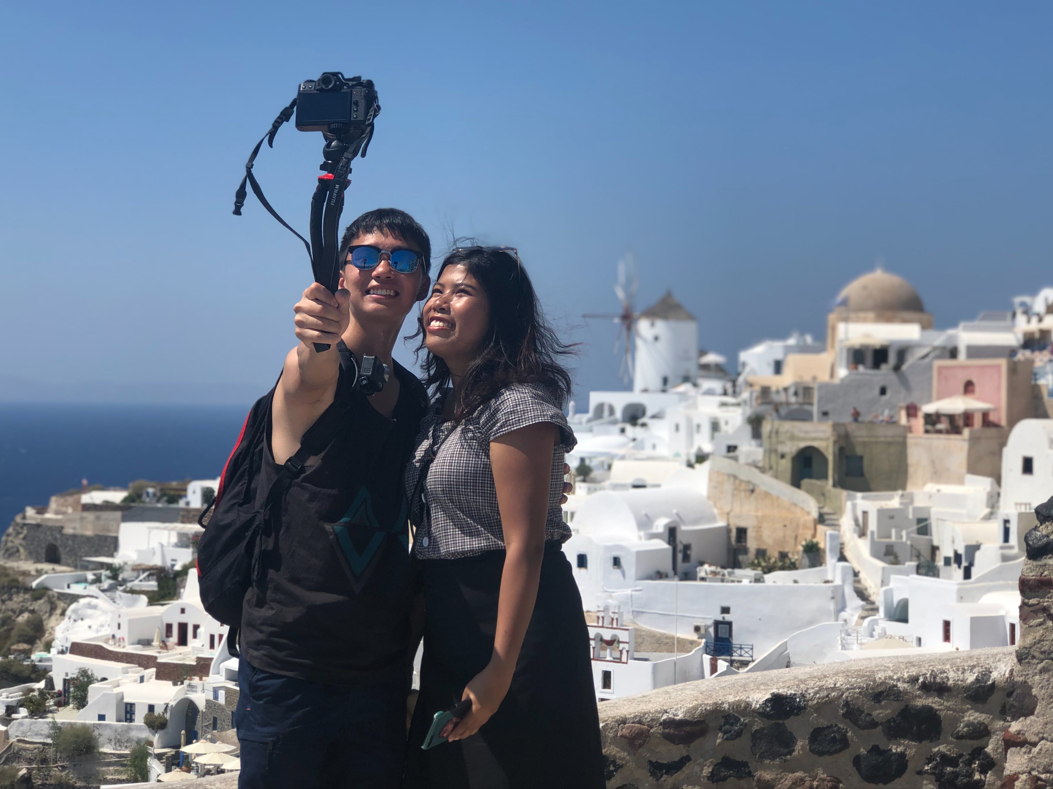 Couple taking a selfie from a high vantage point in Santorini, Greece