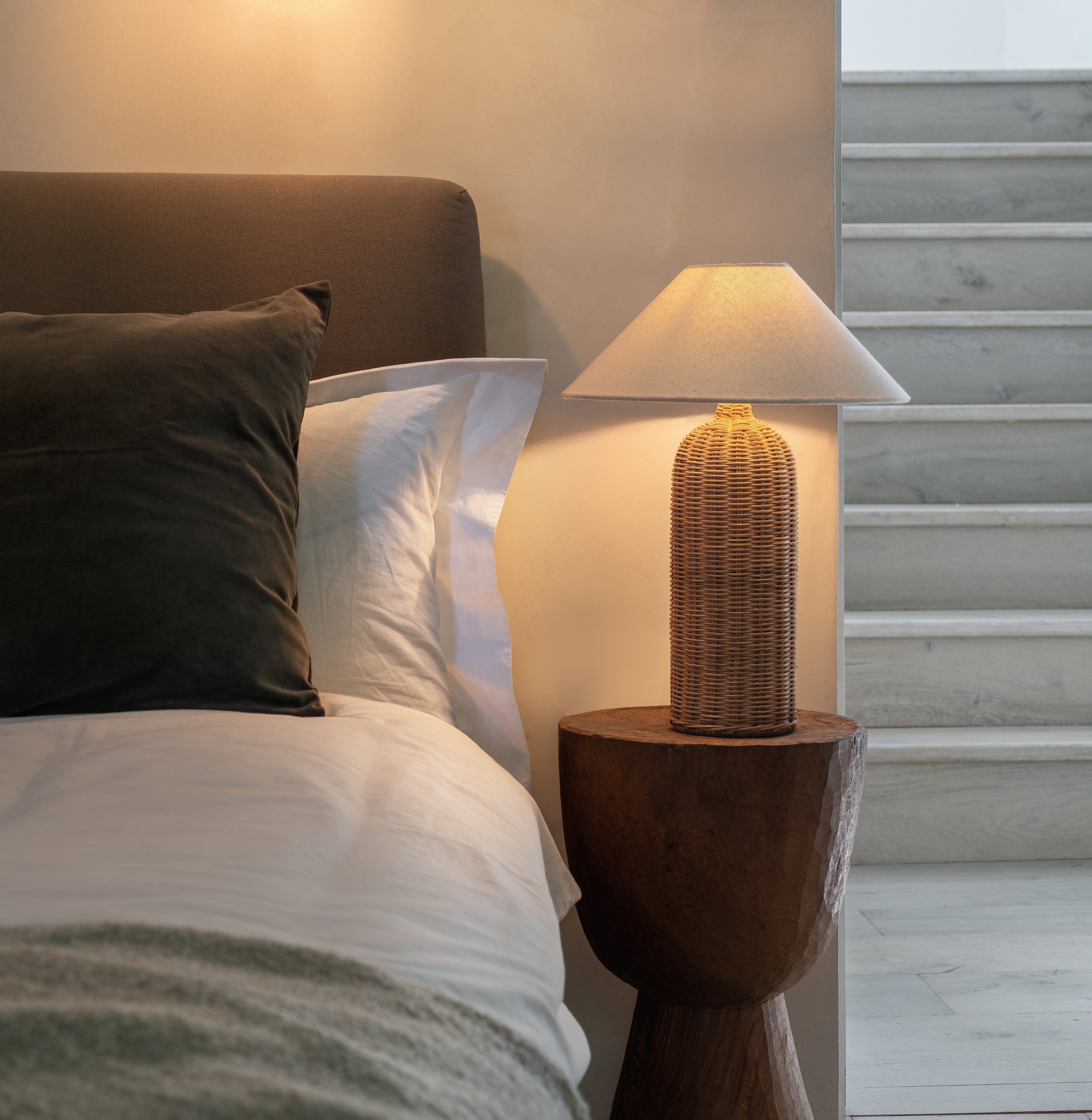 The Ensia rattan-based table lamp gives a room a warm and tranquil light