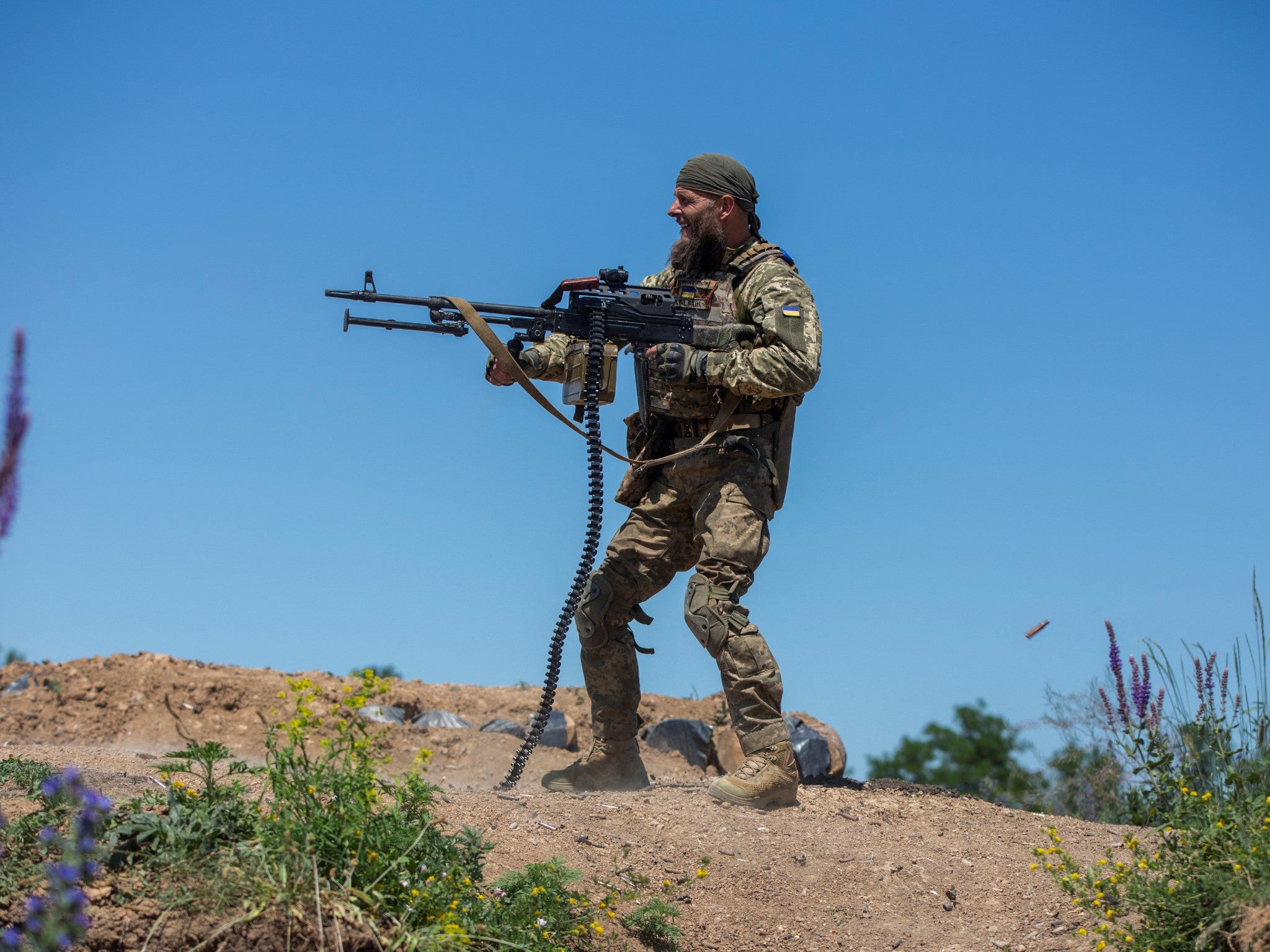 A Ukrainian soldier fires a machine gun at a training ground near the front line in Donetsk