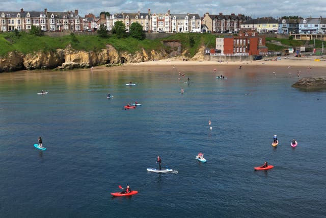 Kayakers and paddleboarders enjoy the sunshine at Cullercoats bay in North Tyneside (Owen Humphreys/PA)