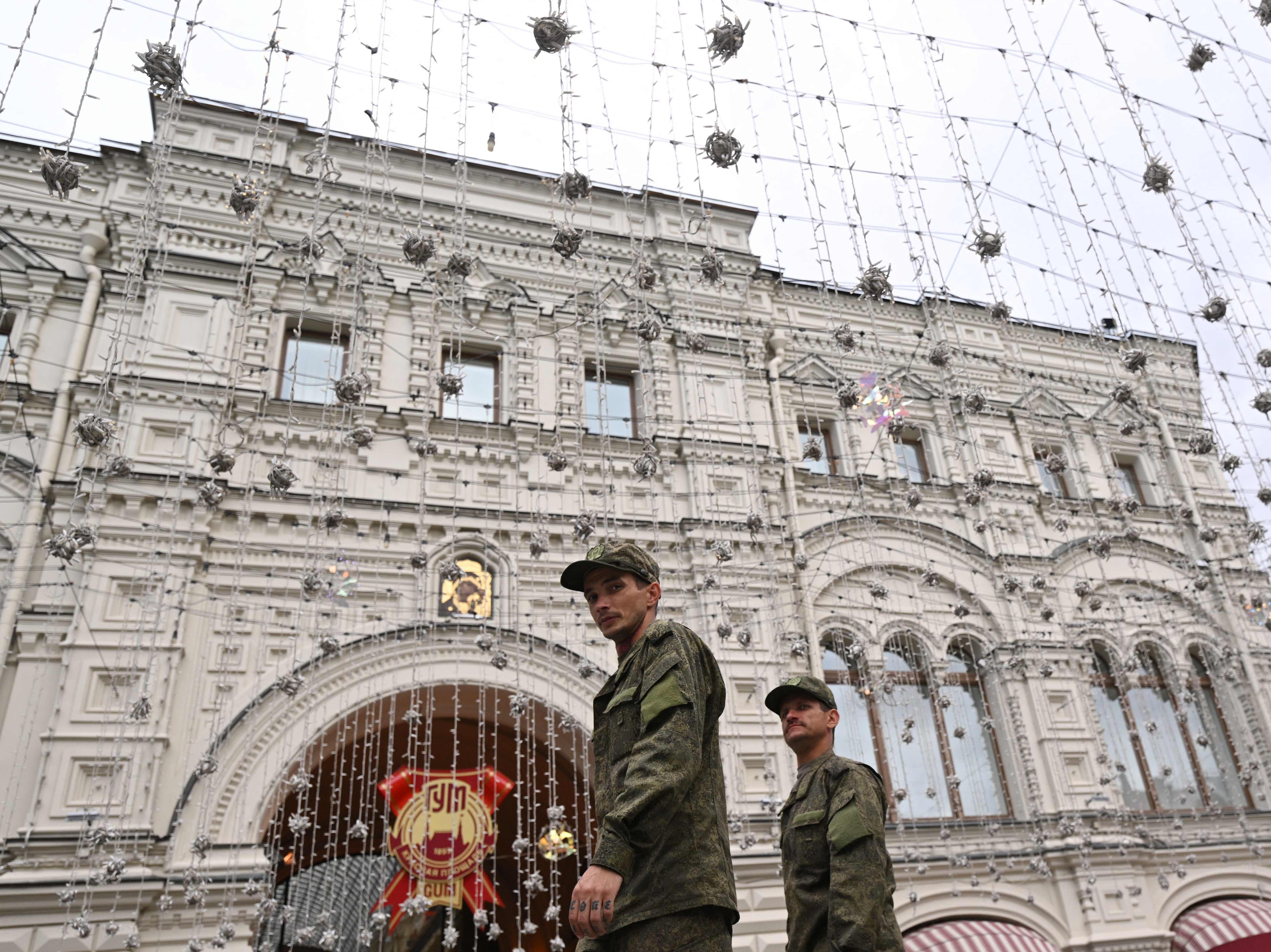 Servicemen walk past the GUM, State Department store, in the centre of Moscow