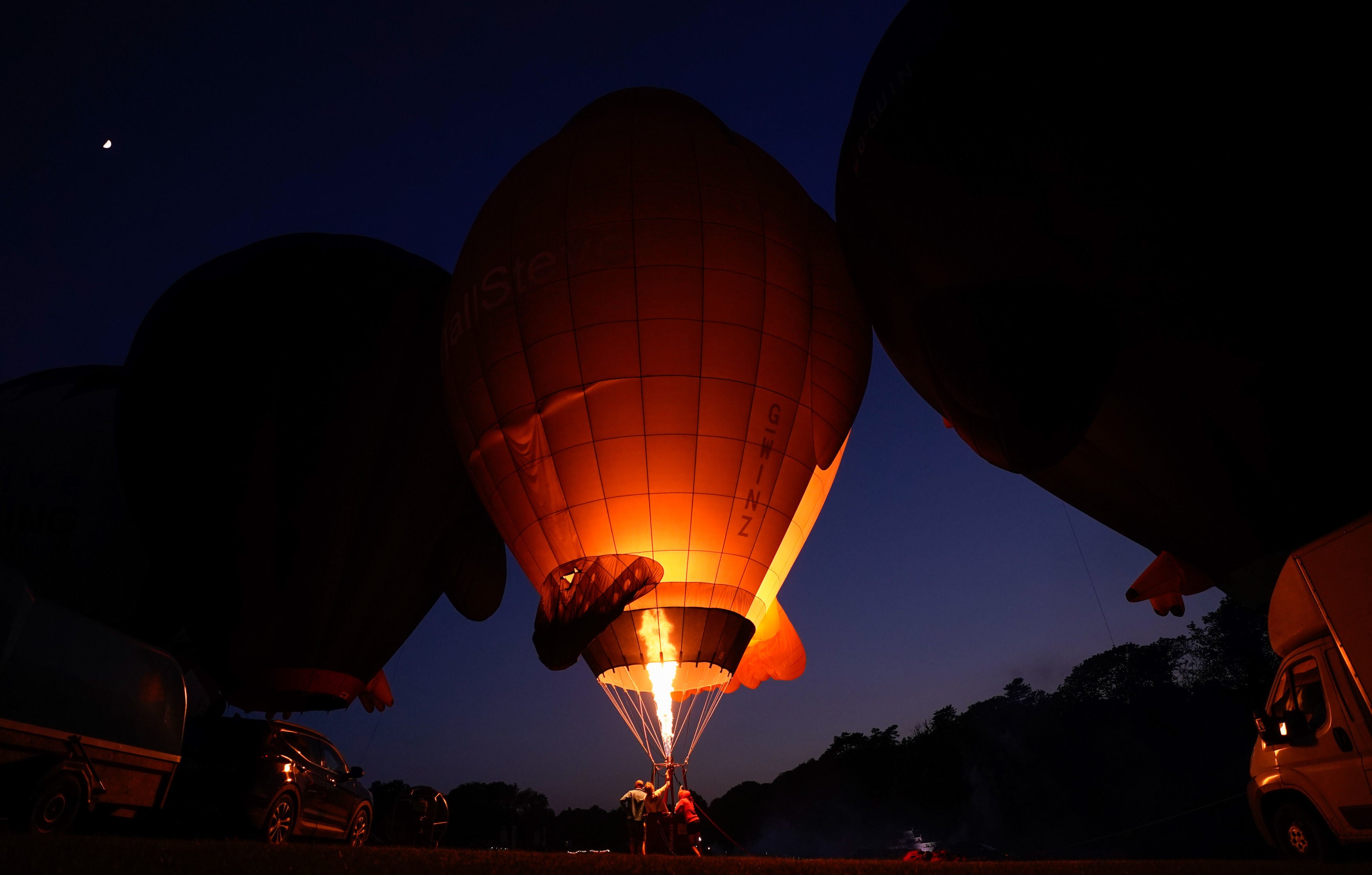 A hot air balloon crew prepare their balloon during the Isle of Wight Balloon Festival at Robin Hill Country Park, Isle of Wight in May