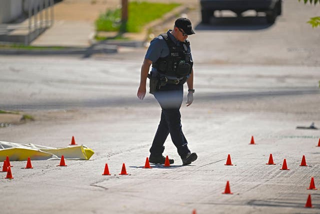 <p>Kansas City police officers survey the site of a mass shooting on 25 June</p>