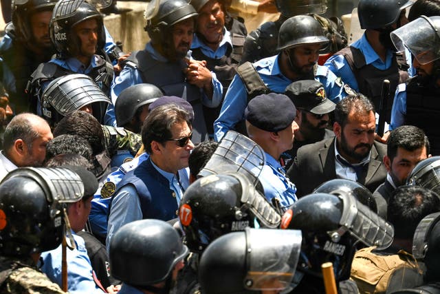 <p>Policemen escort Pakistan’s former prime minister Imran Khan (C) as he arrives at the high court in Islamabad</p>