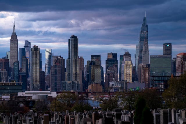 <p>The sun sets behind the New York skyline, Sunday, Nov. 13, 2022, as seen from Calvary Cemetery</p>