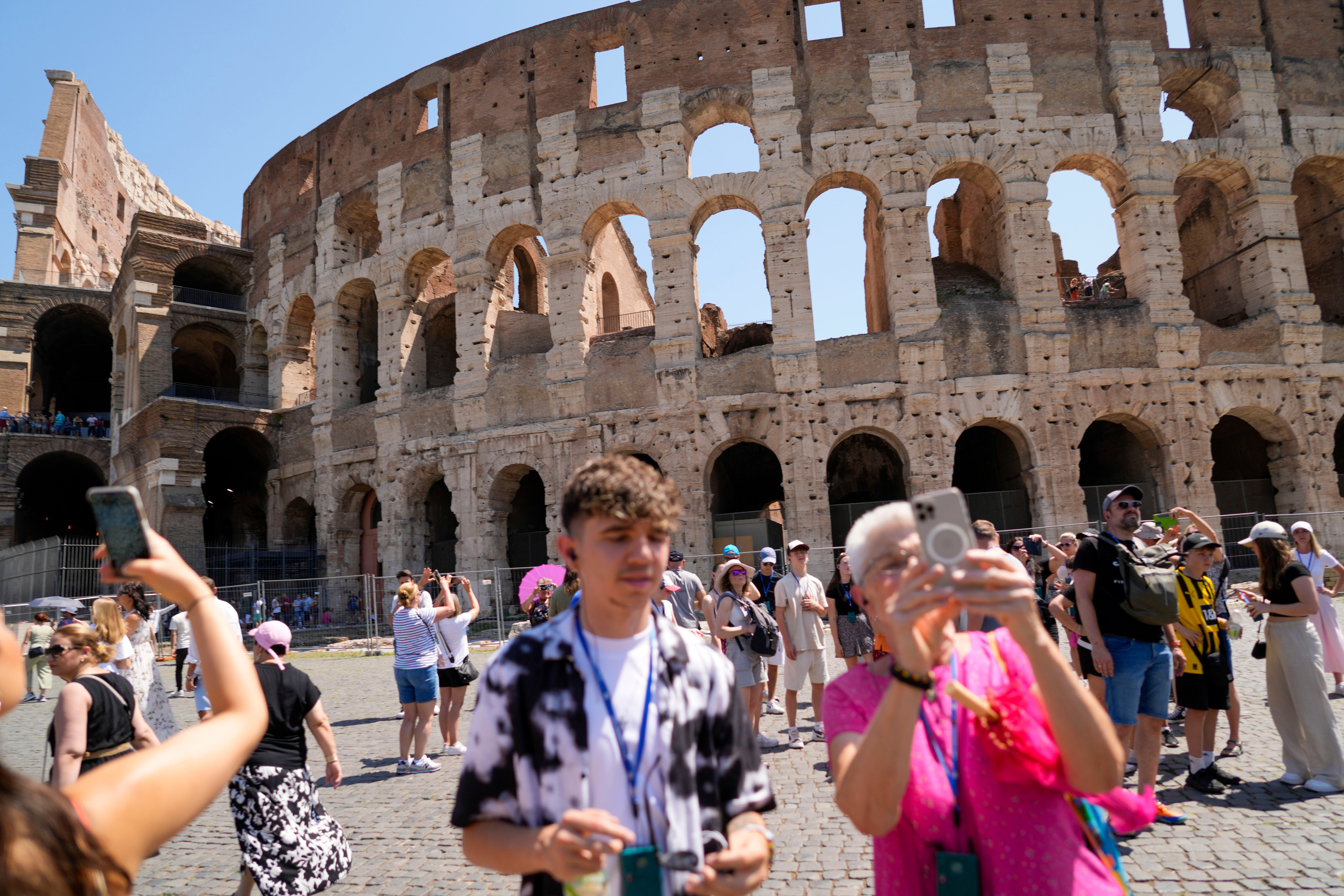 Visitors take photos of the ancient Colosseum in Rome
