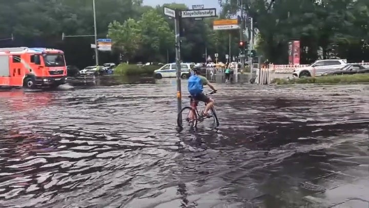 Cyclist and cars wade through Berlin streets amid rain and flooding News Independent TV pic