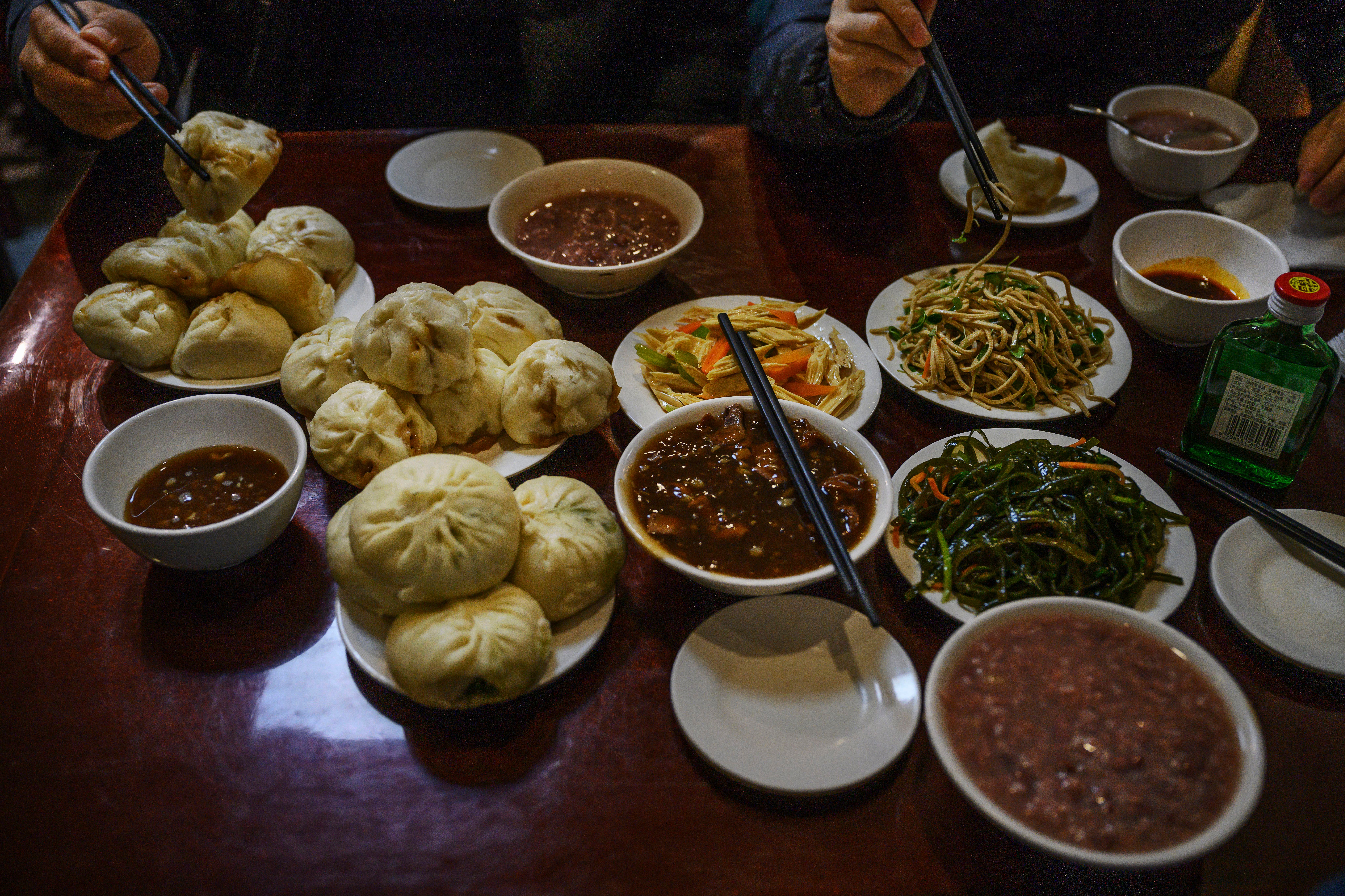 Representative: Dishes of steamed buns and stew and other items are seen on the table at local restaurant