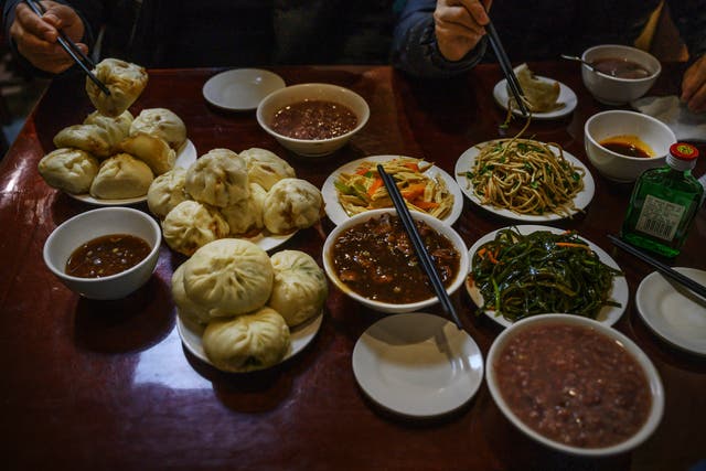 <p>Representative:  Dishes of steamed buns and stew and other items are seen on the table at local restaurant </p>
