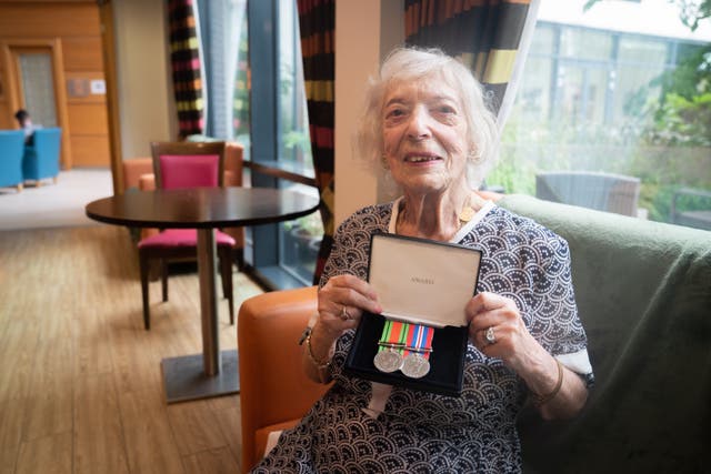 Holocaust survivor Henny Franks holds her war medals as she celebrates her 100th birthday at the Jewish Care Holocaust Survivors’ Centre (James Manning/PA)
