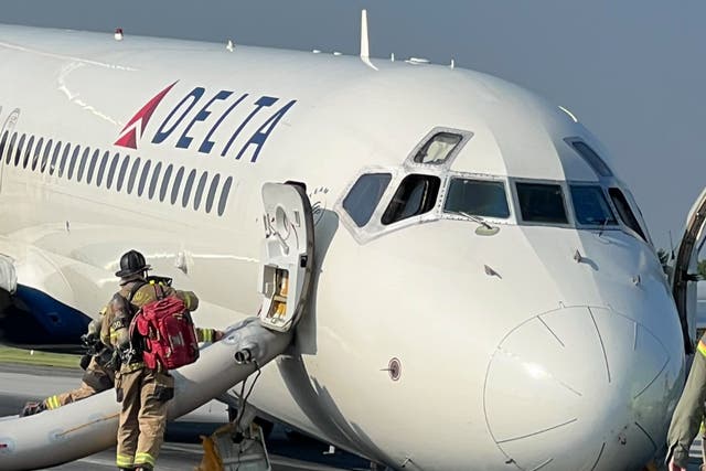 <p>A fire crew responds to a Delta flight at forced to land without its forward landing gear at the Charlotte Douglas International Airport</p>