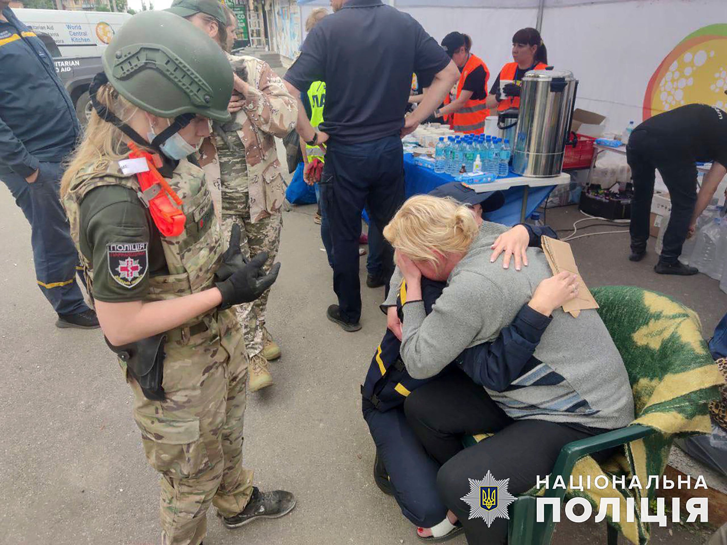 A psychologist of the State Emergency Service of Ukraine, centre, hugs a woman after the strike