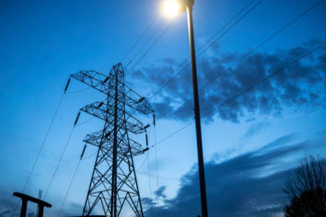 <p>File image: Night time falls behind electricity pylons and a sub station in Manchester. The UK government is going to continue investing in unbataed gas power plants beyond 2030 </p>