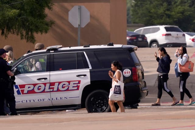 <p>People raise their hands as they leave a shopping center after a shooting in Texas </p>