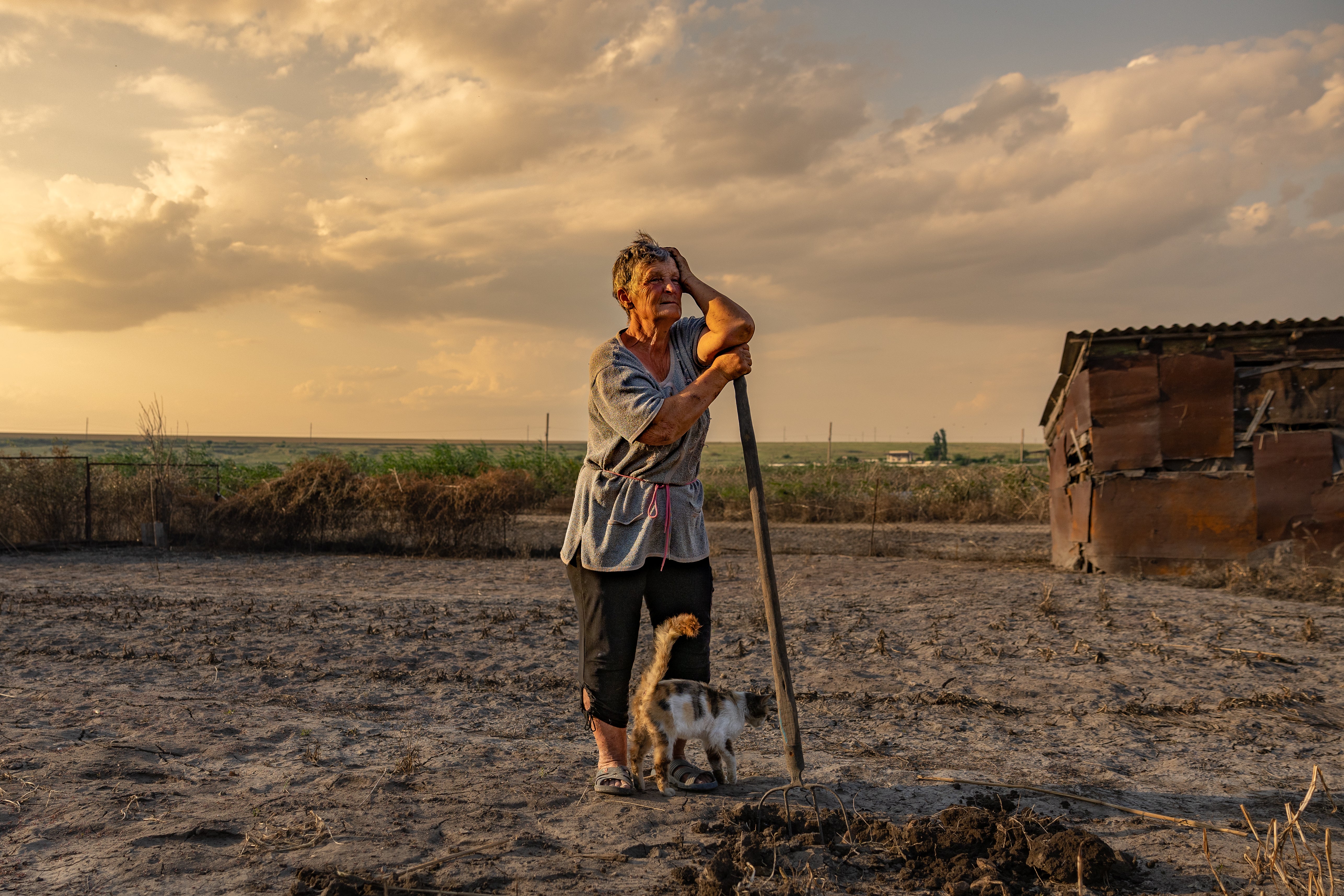 Olha Mosyk stands on her land destroyed by the flood from the exploded dam in Kherson