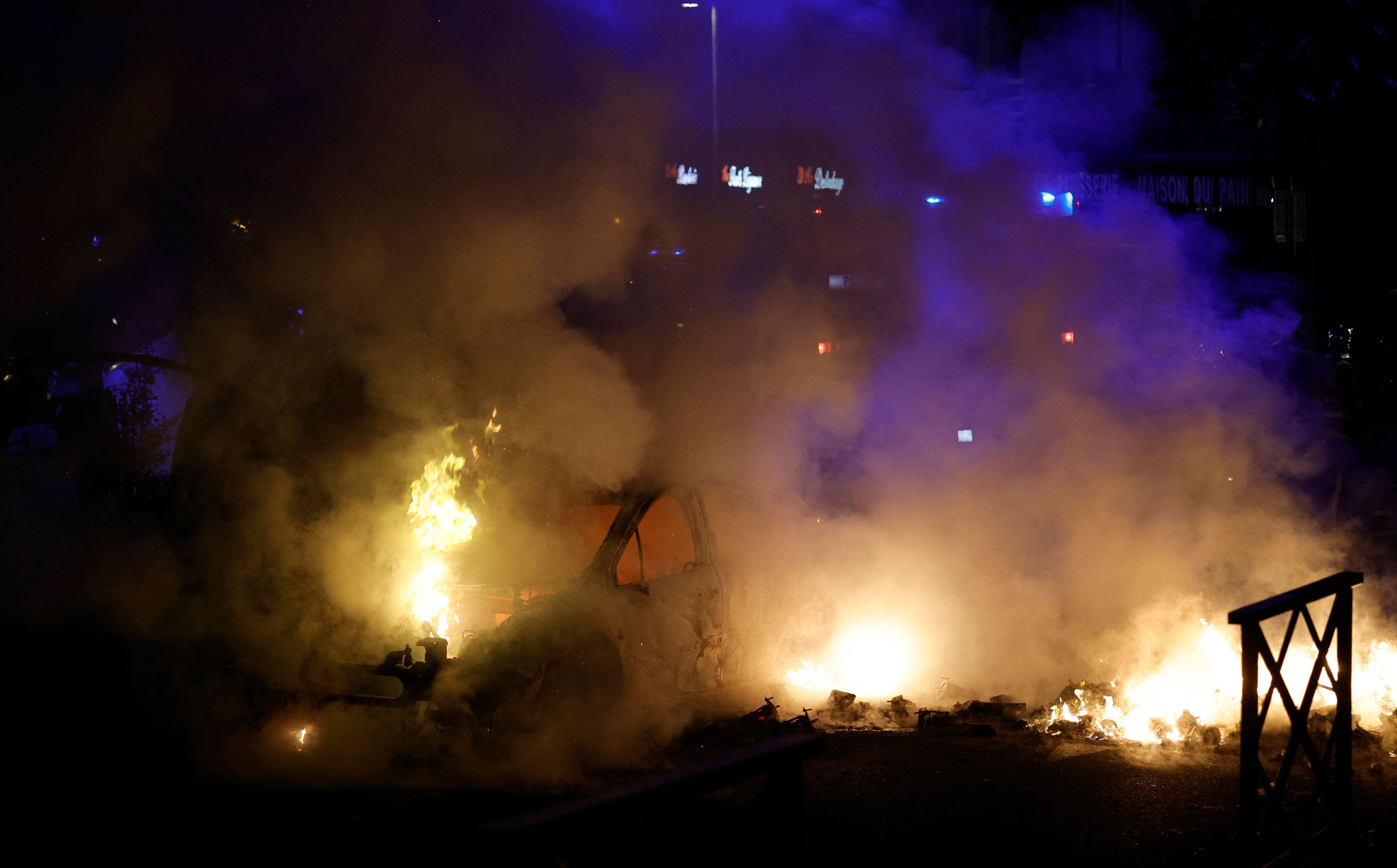 Smoke rises from a car set ablaze during protests in Nanterre, west of Paris, on the early hours of 29 June 2023