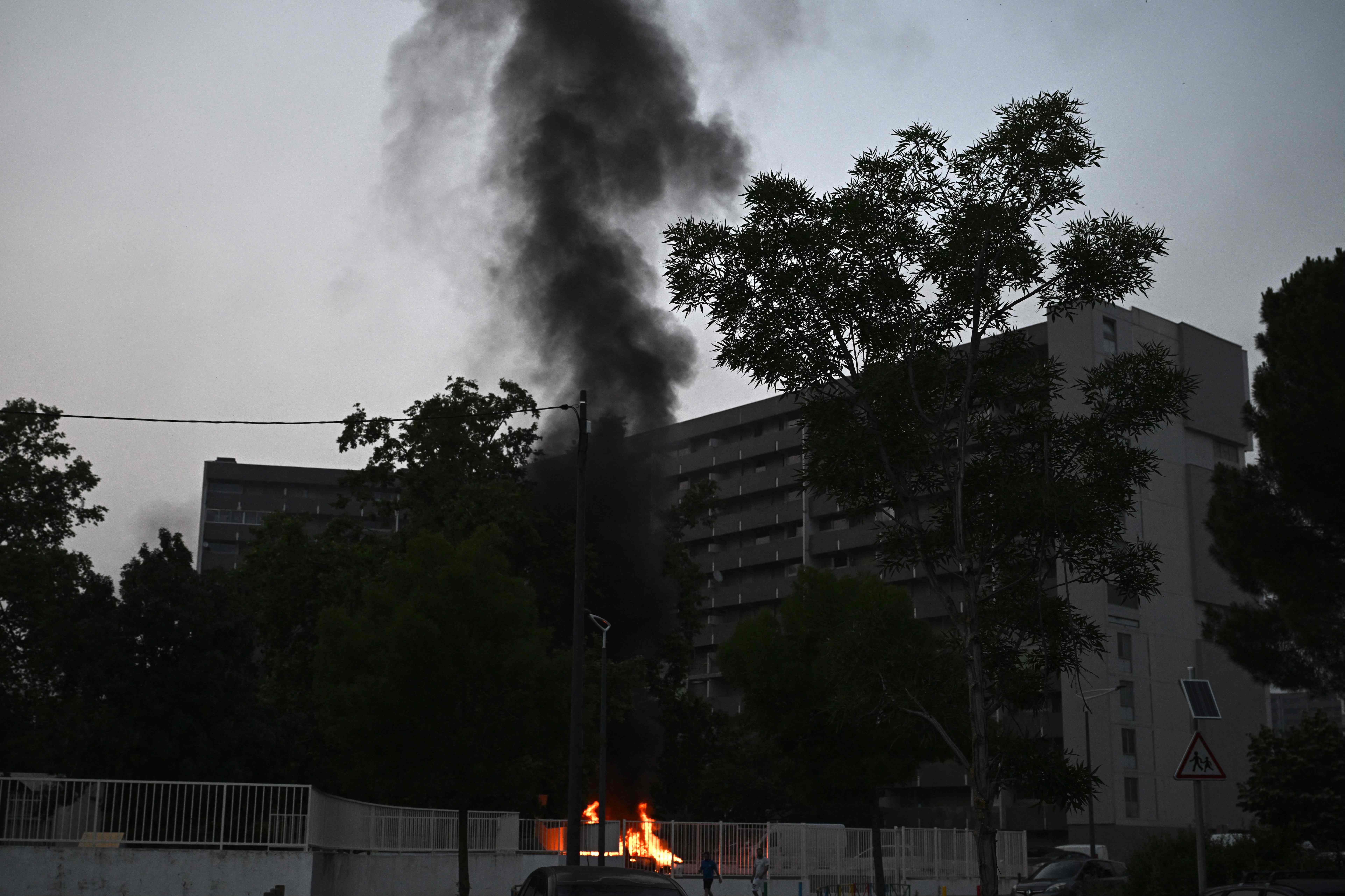 Smoke rises from a bonfire in a residential area during clashes in Toulouse, southwestern France on 28 June 2023