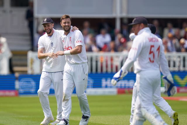 England’s Chris Woakes and Ollie Robinson celebrate the wicket of Australia’s Nathan Lyon, not pictured (PA)