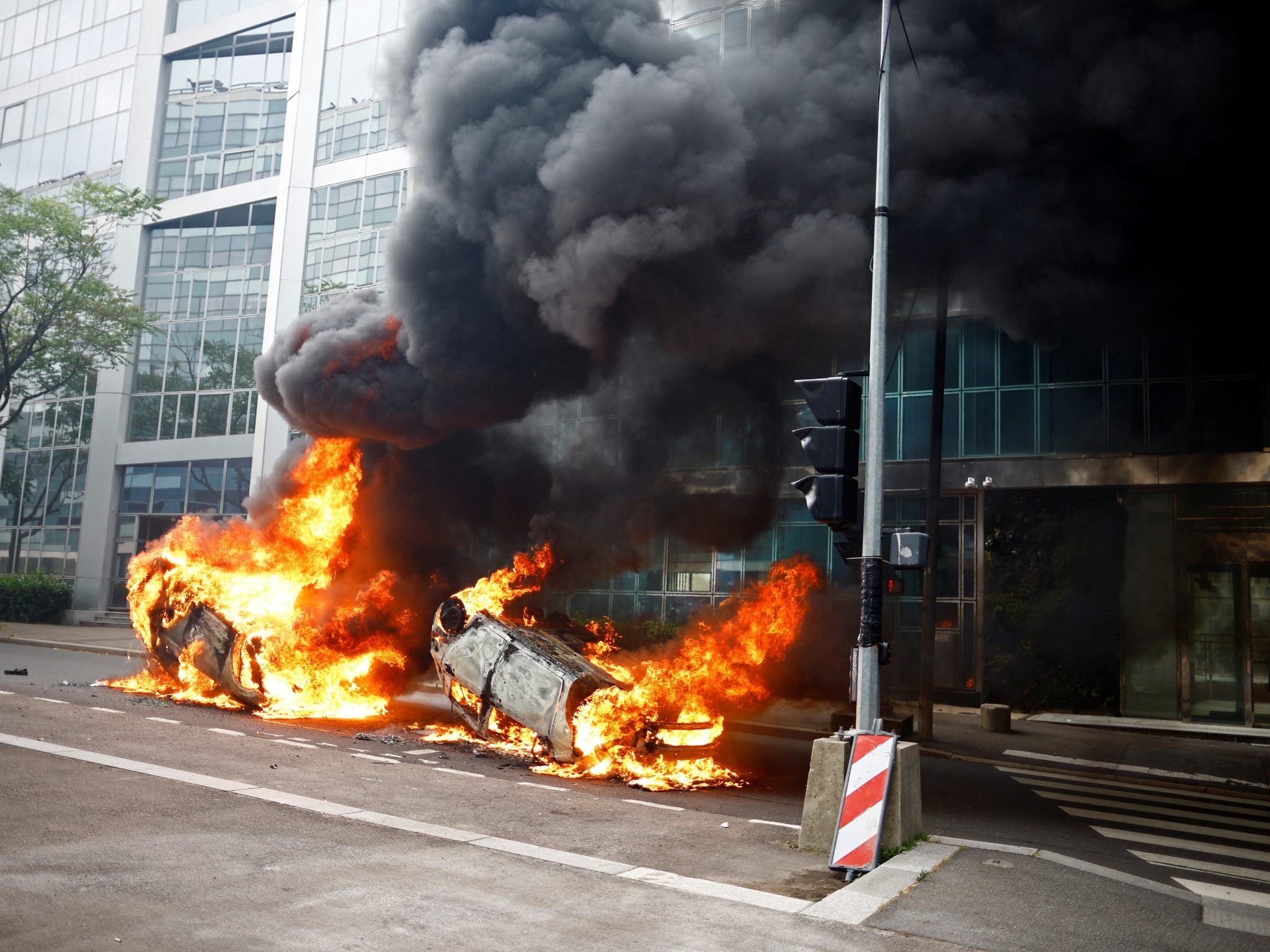 <p>Burning vehicles on a street in Nanterre amid clashes between protesters and police</p>