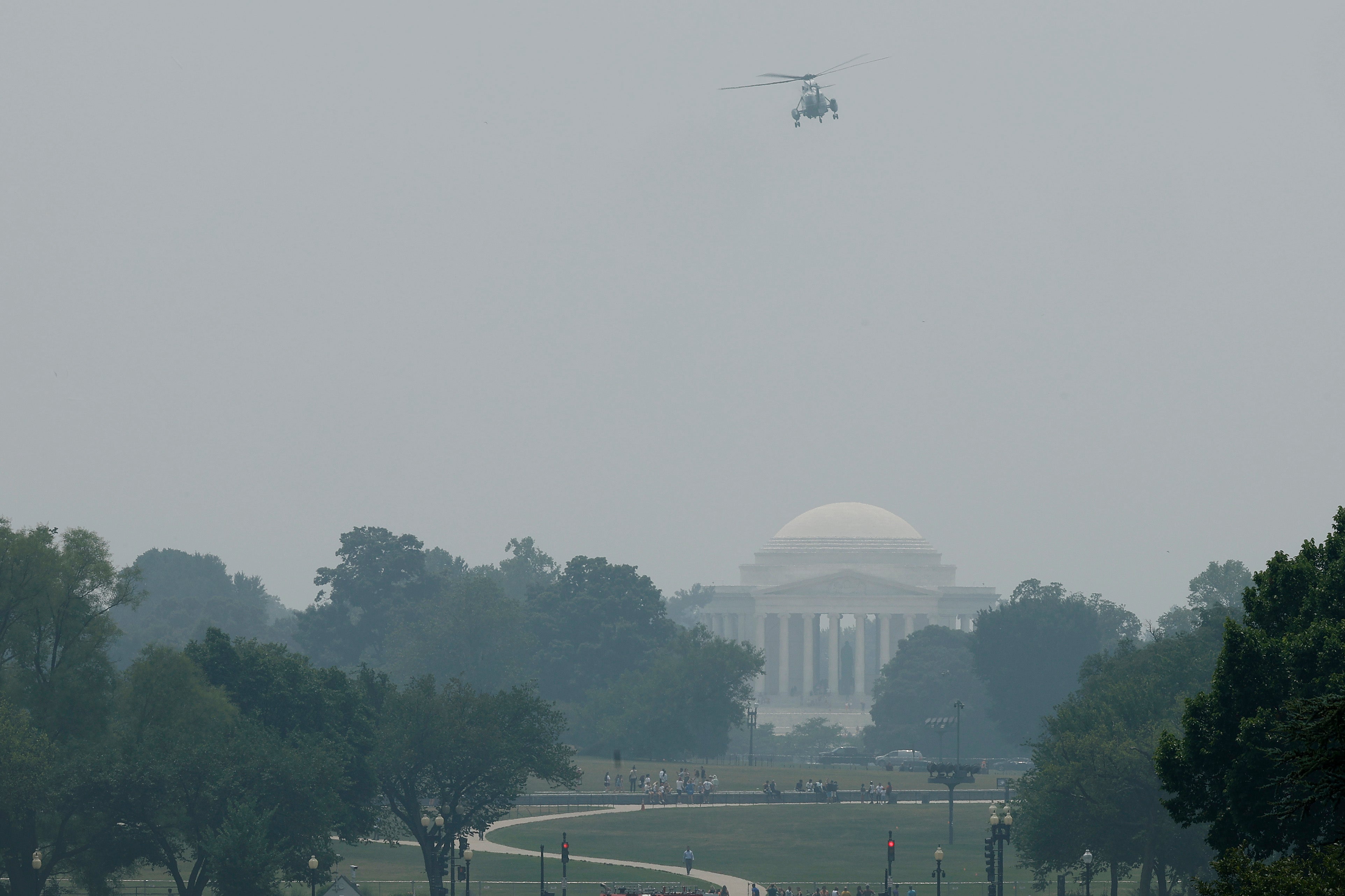 Marine One, with President Joe Biden on board, flys past the Jefferson Memorial as it appears hazy from wild fire smoke