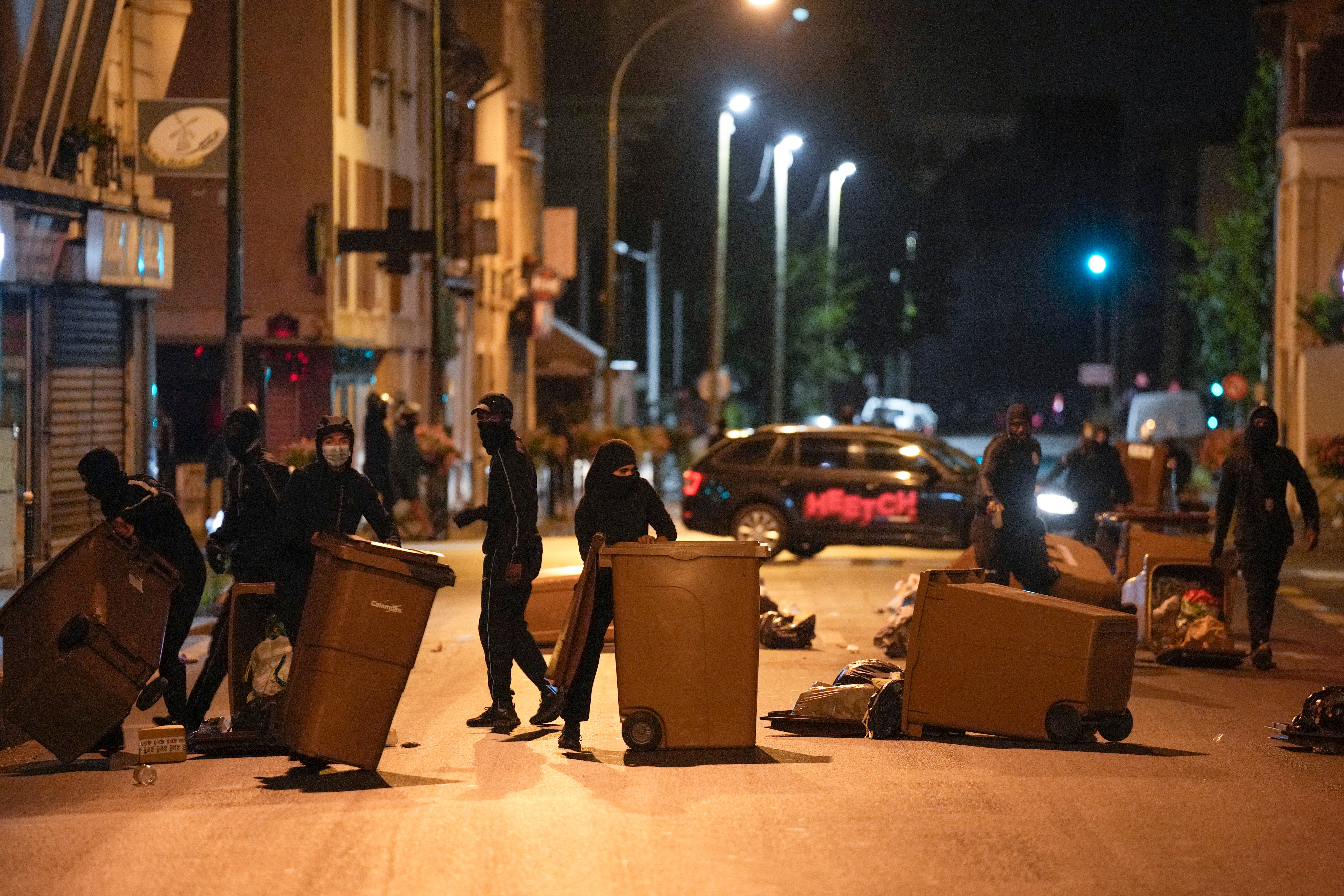 Protesters block a street with garbage cans in Colombes, outside Paris