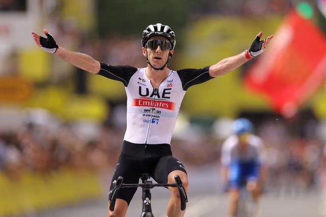 <p>Adam Yates celebrates claiming victory and the yellow jersey ahead of brother Simon </p>
