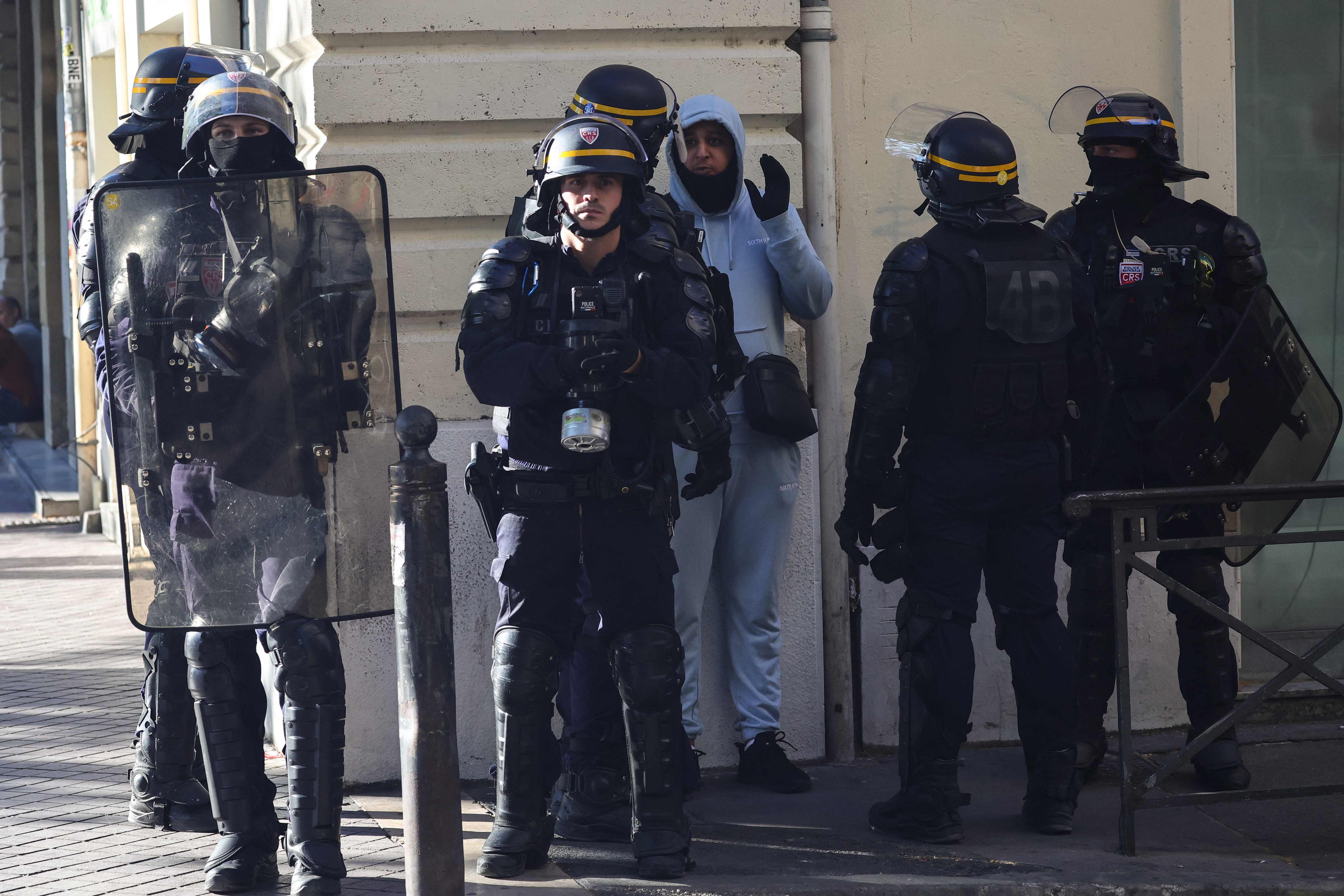 A man reacts as he is detained and questioned by police officers during a demonstration against police in Marseille