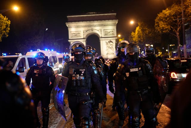 <p>Police officers patrol in front of the Arc de Triomphe on the Champs Elysees in Paris on Saturday</p>