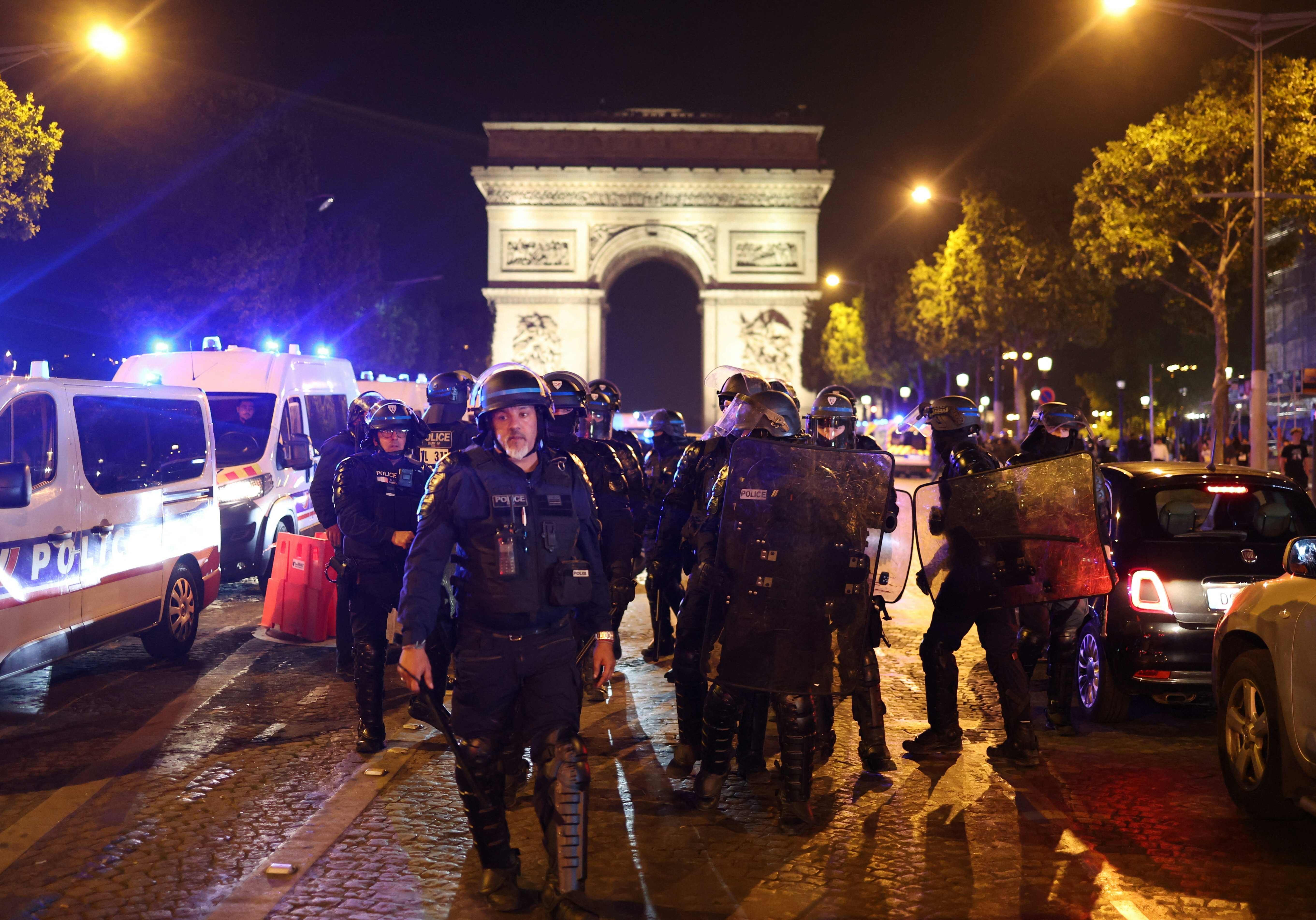 French police officers patrol in front of the Arc de Triomphe in the Champs Elysees area of Paris