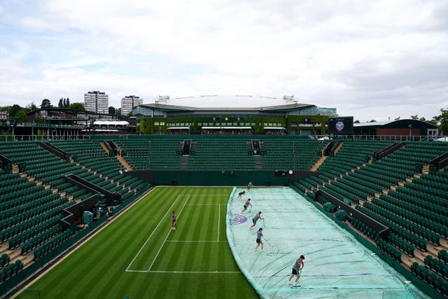 Ground staff practise moving the covers on the outside courts at the All England Lawn Tennis and Croquet Club in Wimbledon (PA)