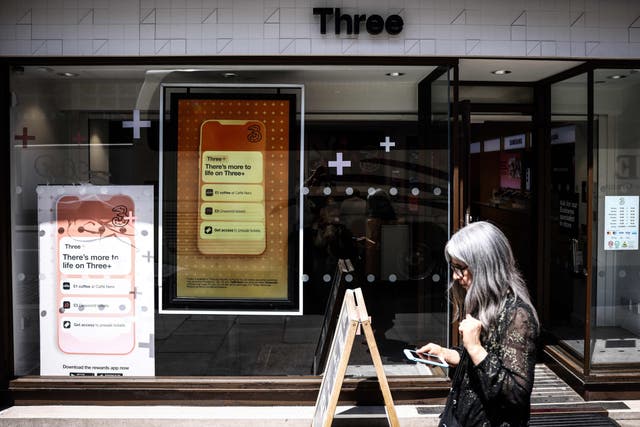 <p>A pedestrian walks past a Three UK mobile phone shop, in central London, on June 14, 2023</p>