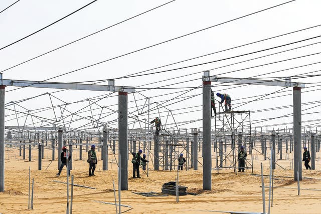 <p>Workers set up frameworks for a solar power project in Kubuqi desert in the Inner Mongolia autonomous region </p>
