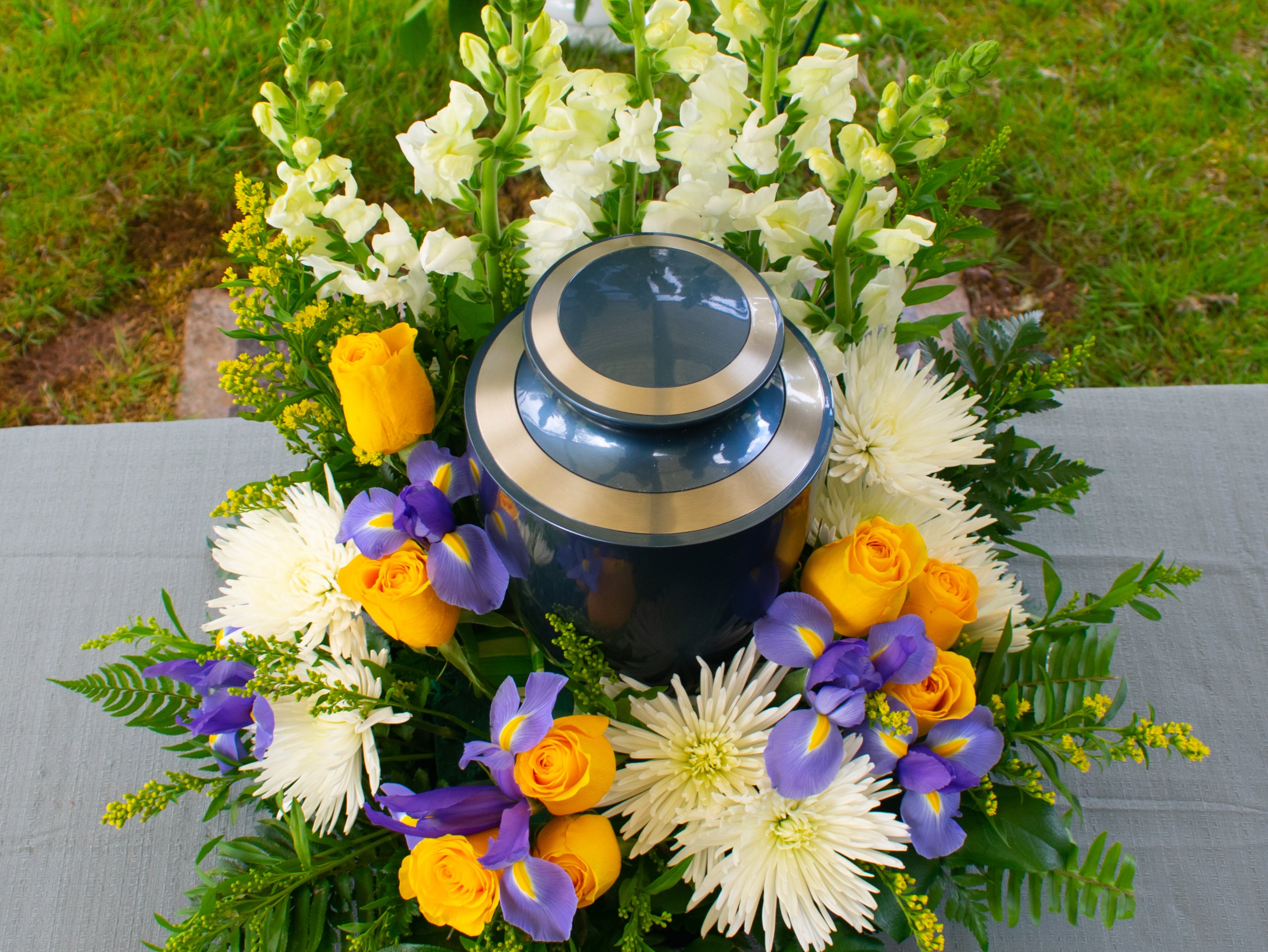 A cremation urn with floral arrangement at a funeral ceremony