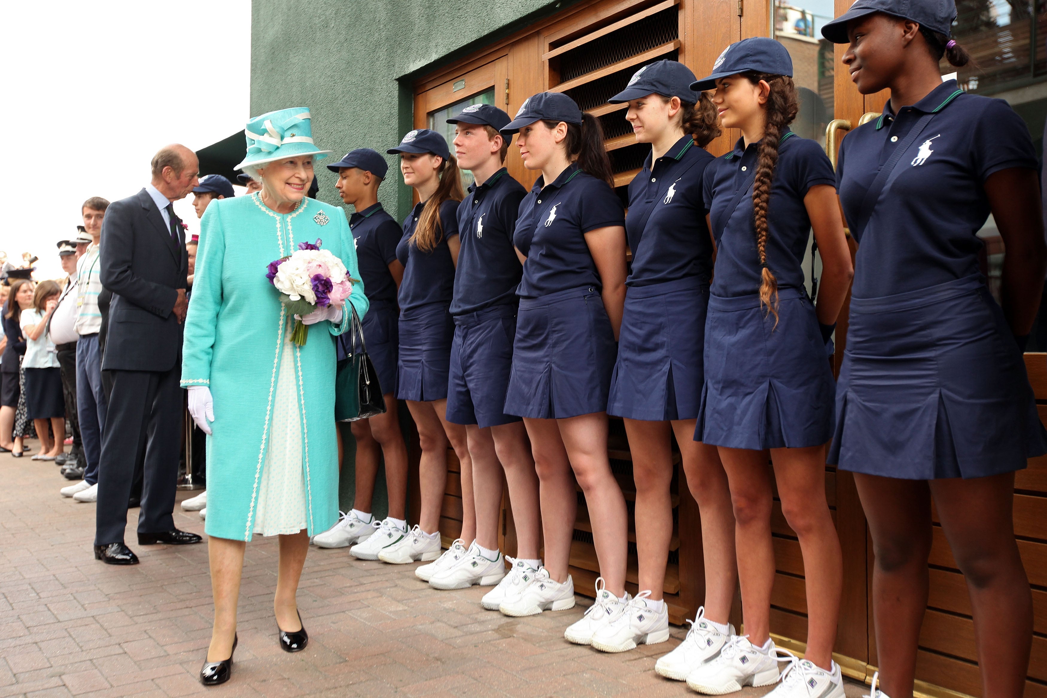 Queen Elizabeth II speaks to ball boys and girls as she attends the Wimbledon Lawn Tennis Championships on Day 4 at the All England Lawn Tennis and Croquet Club on June 24, 2010