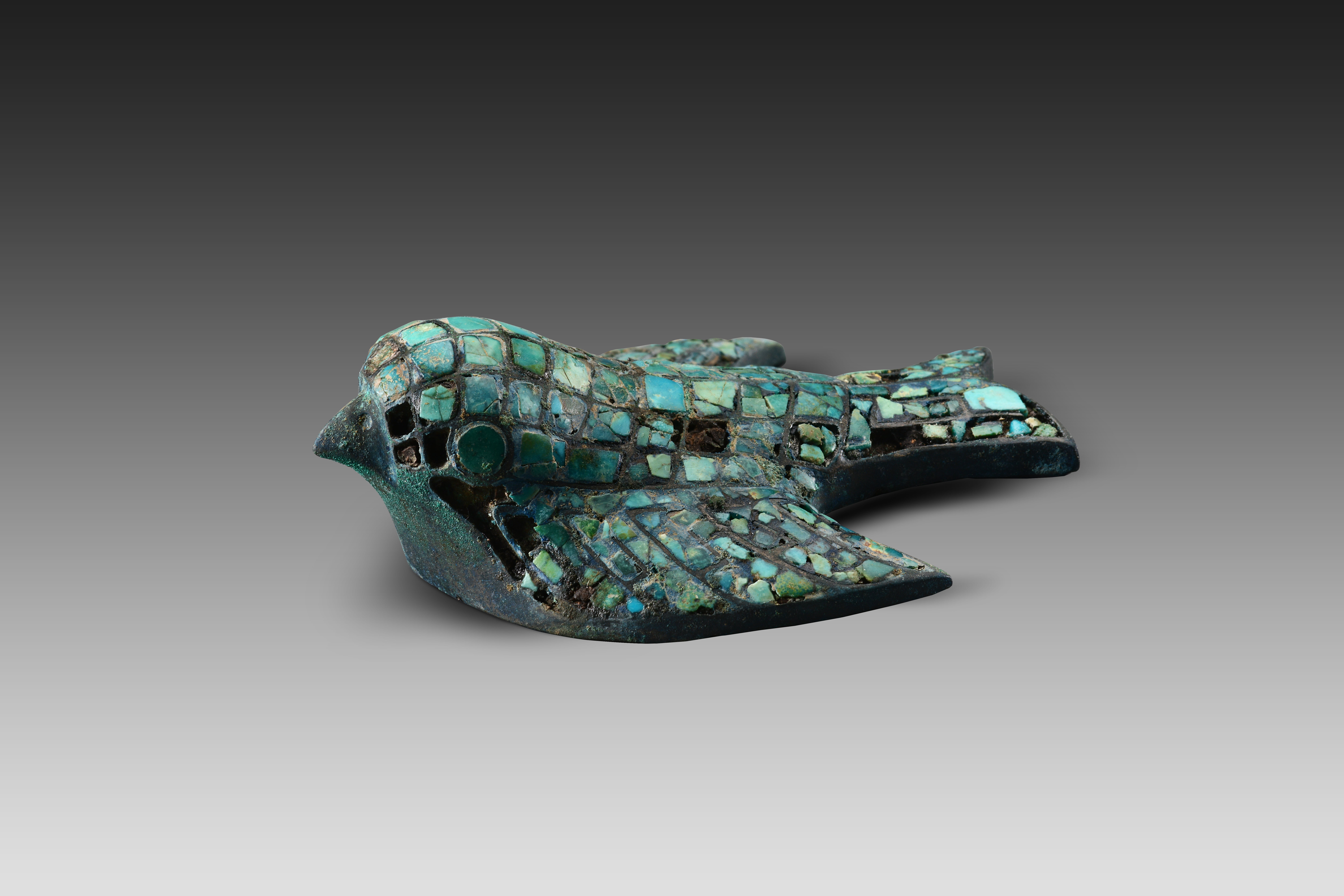 A bronze ornament in the shape of a bird decorated with turquoises found at the Zhaigou site