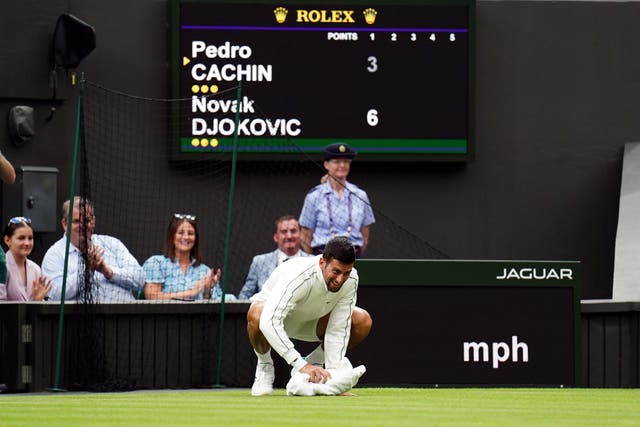 Novak Djokovic dries the wet court with a towel (Zac Goodwin/PA)