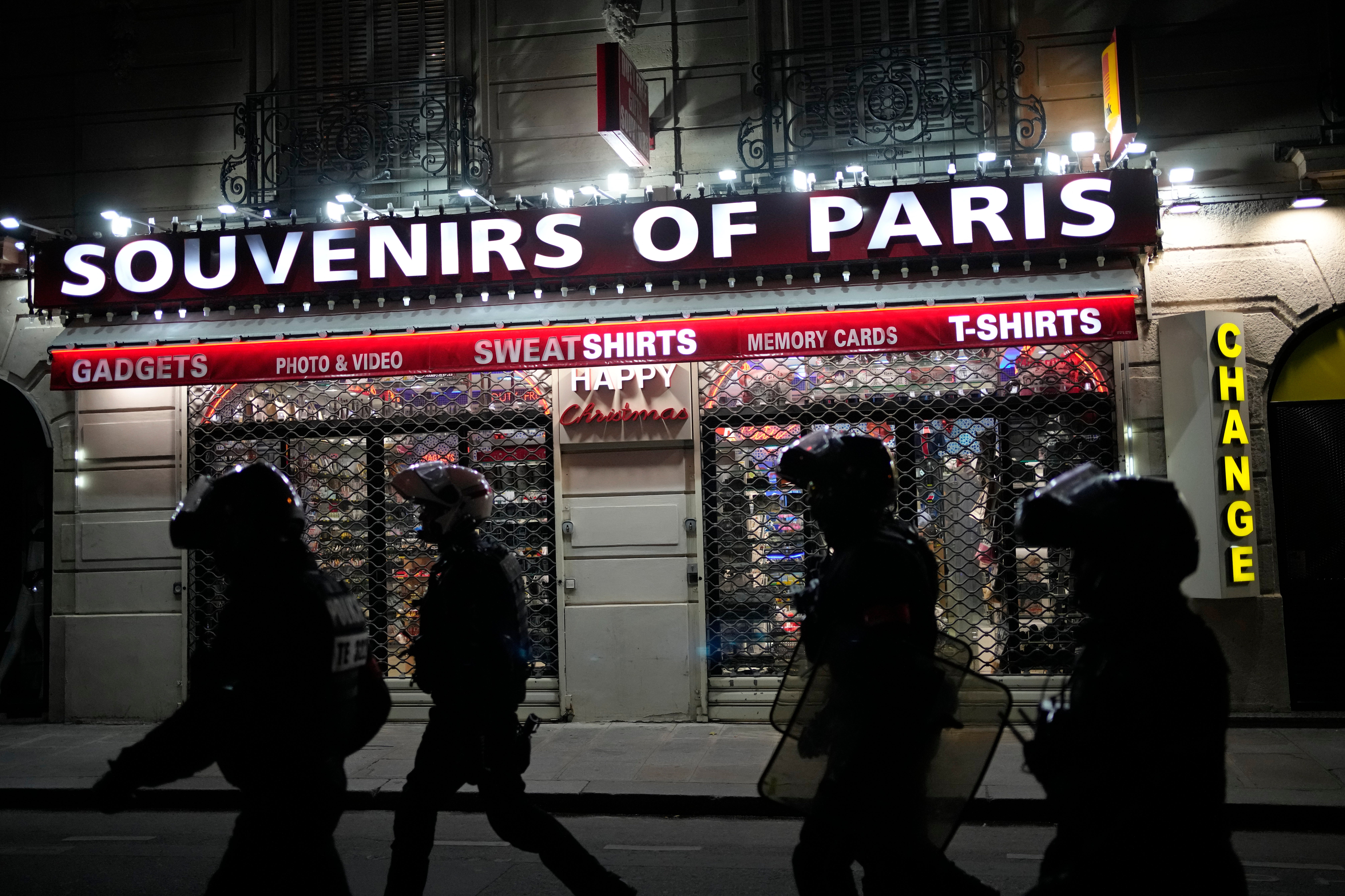 Police officers walk past a souvenir store in Paris on Saturday