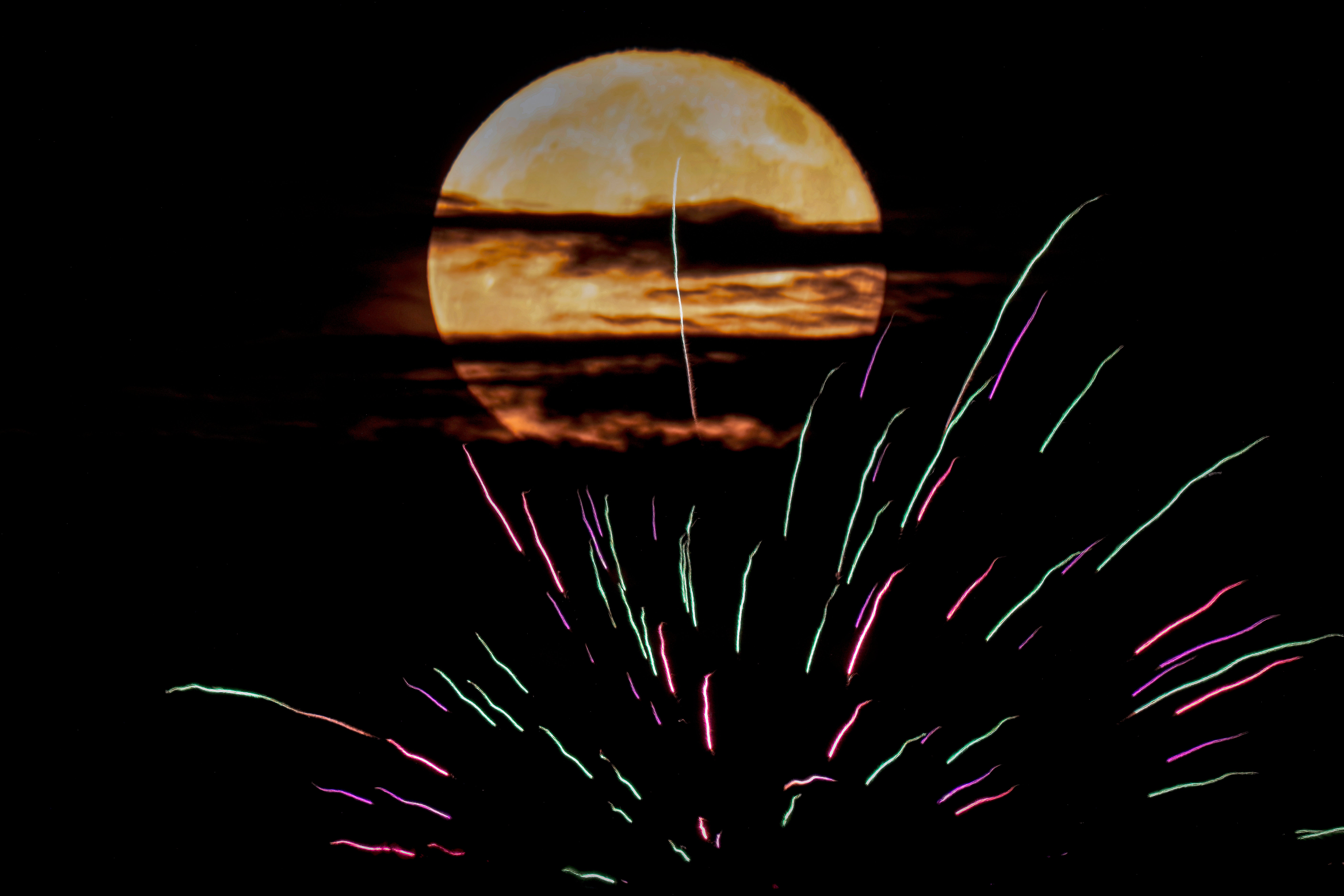 The buck supermoon rises behind fireworks Monday, 3 July, 2023, in Kansas City, US