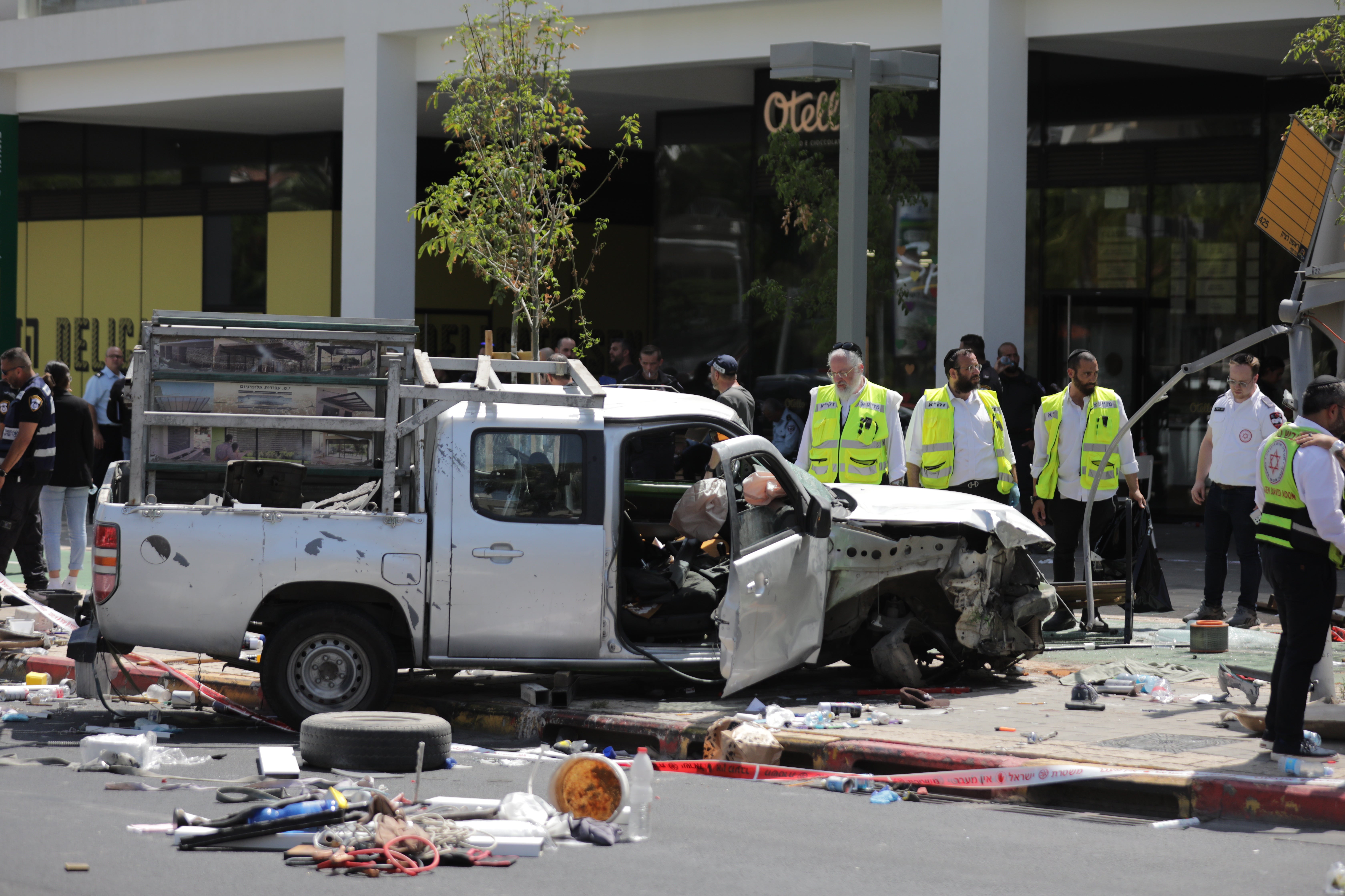 Israeli security forces and emergency workers stand near the site of a car ramming attack