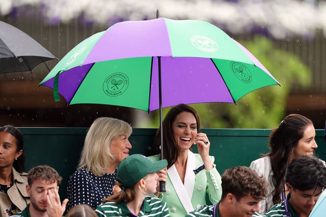 The Princess of Wales under an umbrella with Deborah Jevans before rain stops play in the match between Katie Boulter and Daria Saville on day two of the 2023 Wimbledon Championships (PA)
