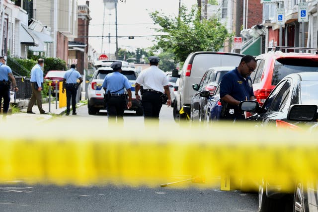 <p>Police officers work at the scene as investigations are ongoing the day after a mass shooting in the Kingsessing section of southwest Philadelphia, </p>