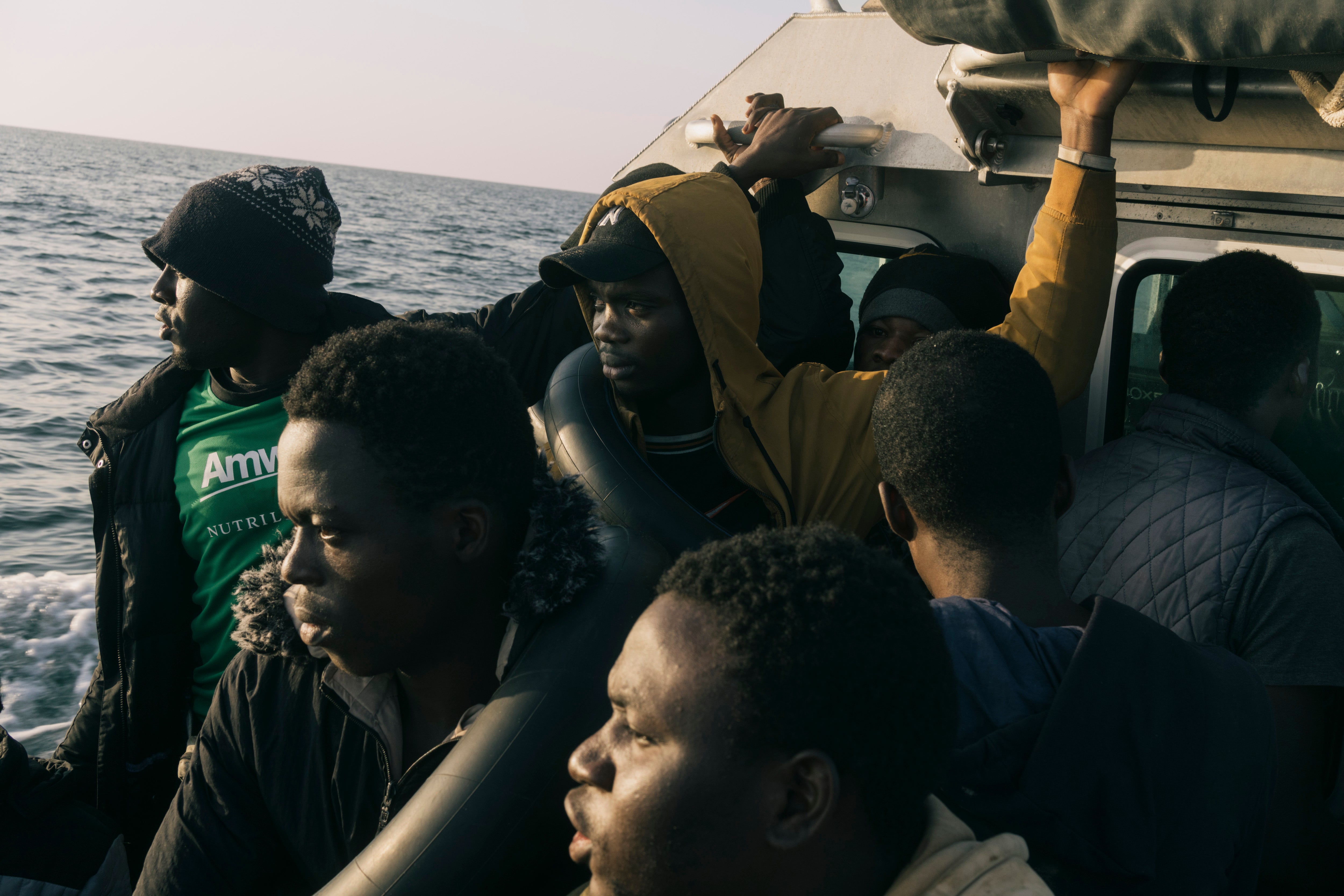 Migrants are transported to the Tunisian Coast Guard’s main vessel after their boat was intercepted near Sfax on 27 May