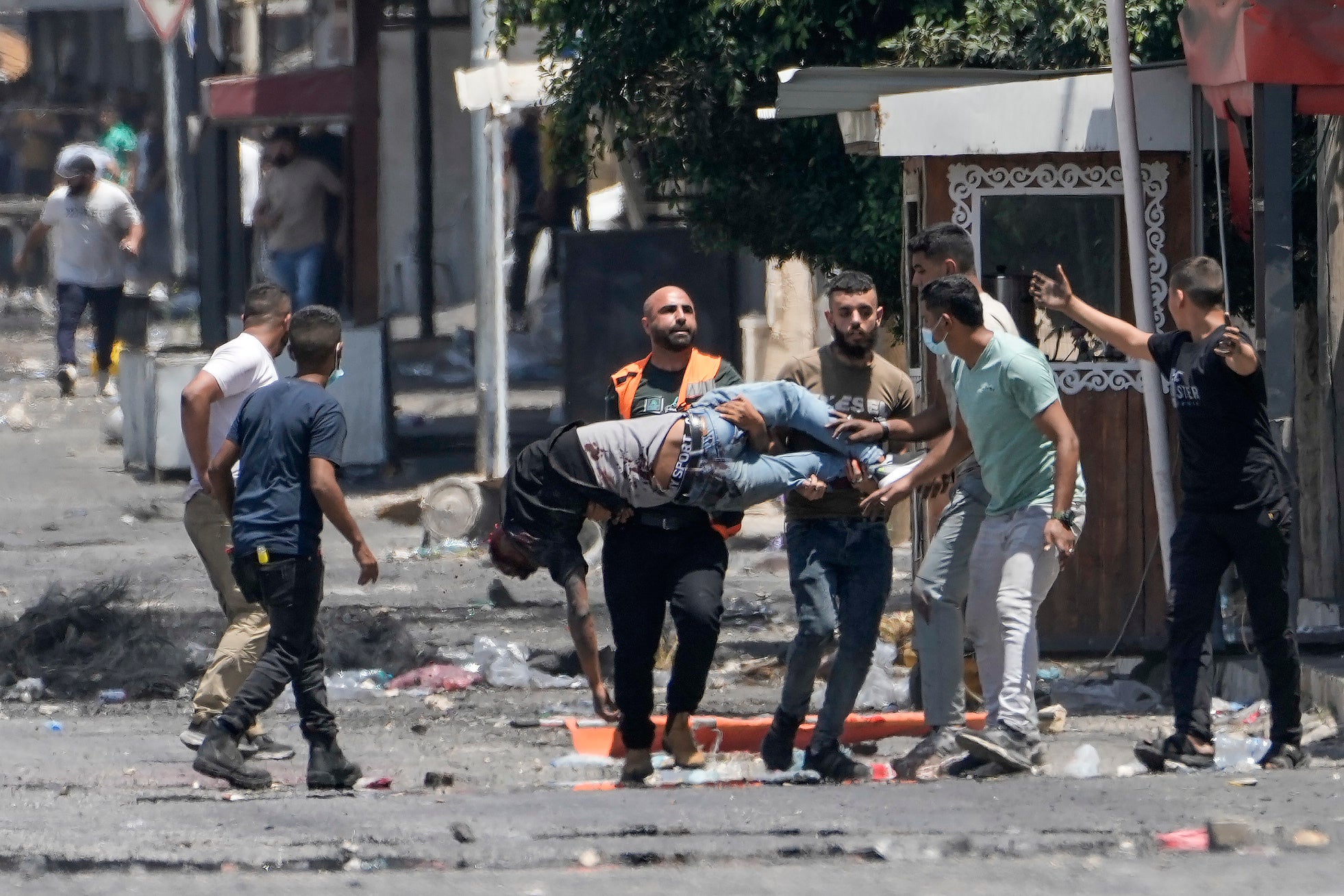 Palestinians carry a wounded man shot by Israeli fire in Jenin on Tuesday
