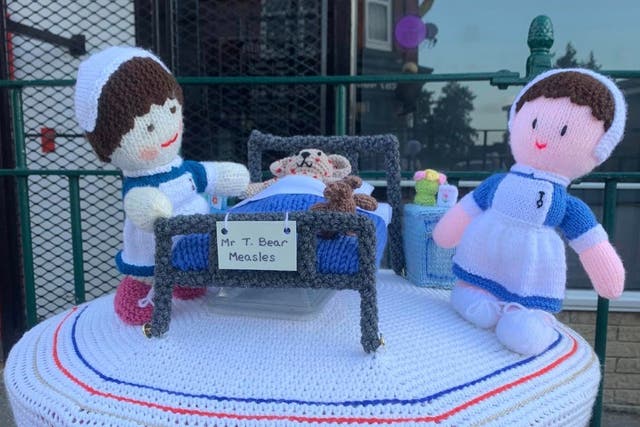 Baby hats knitted by Knit and Natter members in Kippax for the NHS anniversary and a postbox topper knitted for the anniversary (Kathleen Jackson/PA)